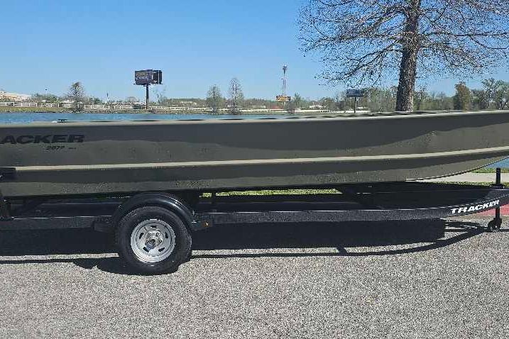 2025 Tracker Grizzly 2072 Utility boat on trailer by a lake.