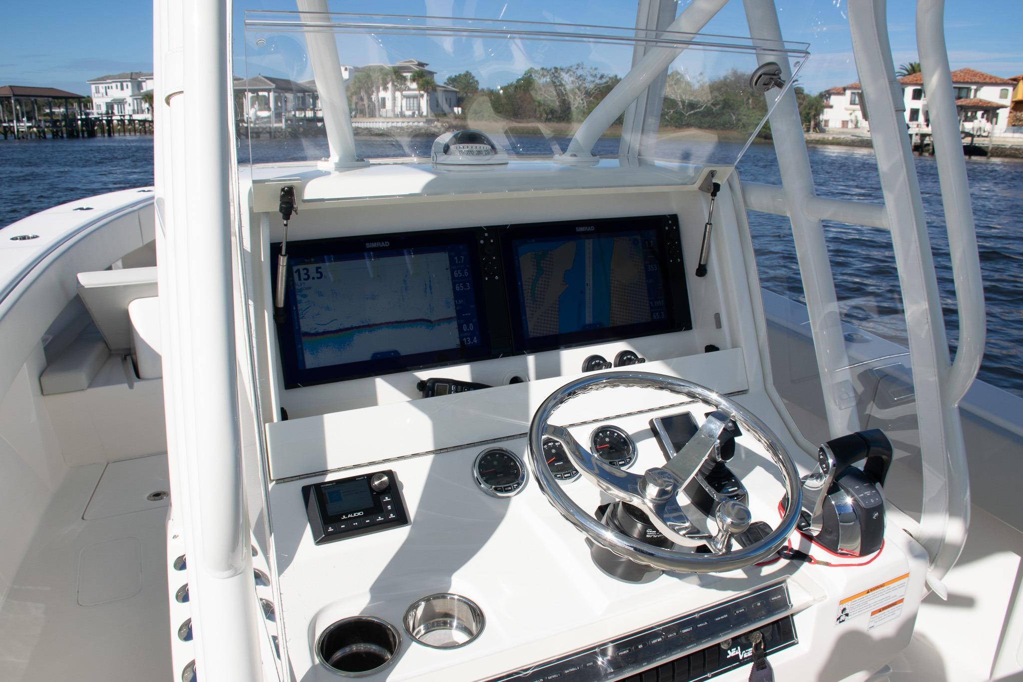 2022 SeaVee 322Z boat helm with dual displays and steering wheel on water.