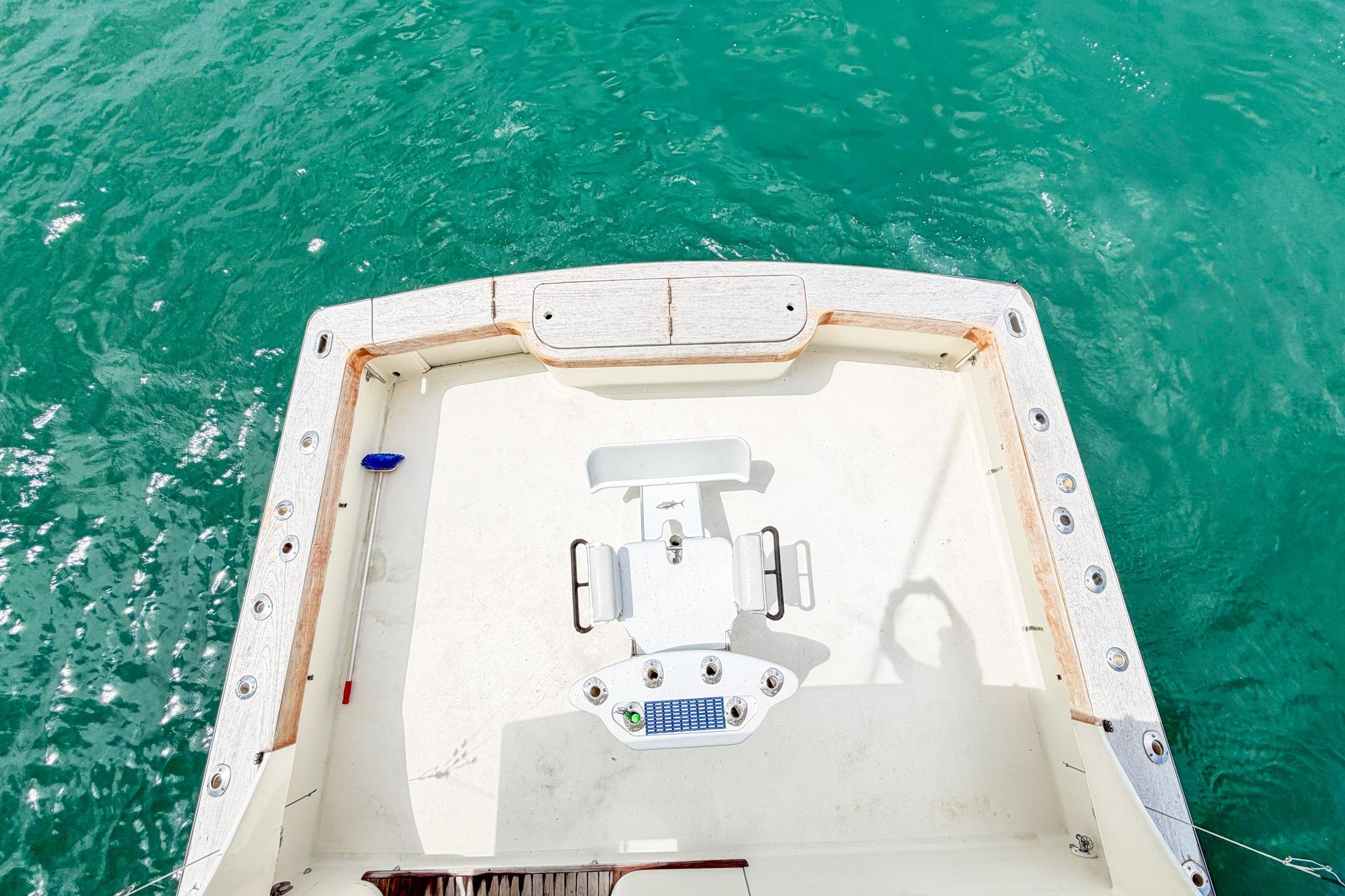 1998 Blackwell Custom Carolina Sportfish boat deck with fishing chair, surrounded by turquoise water.