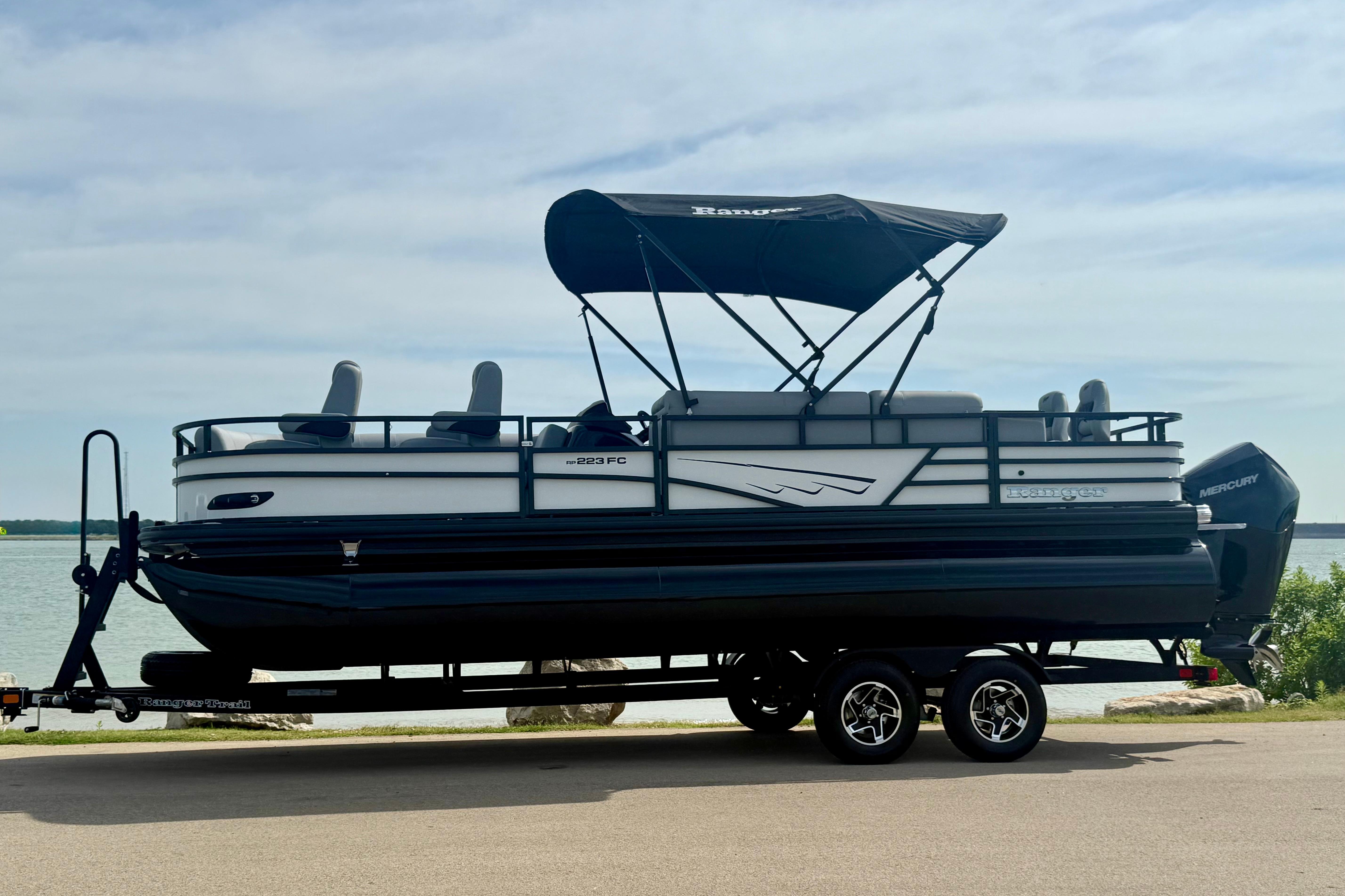 2026 Ranger 223FC pontoon boat on trailer by a lake.