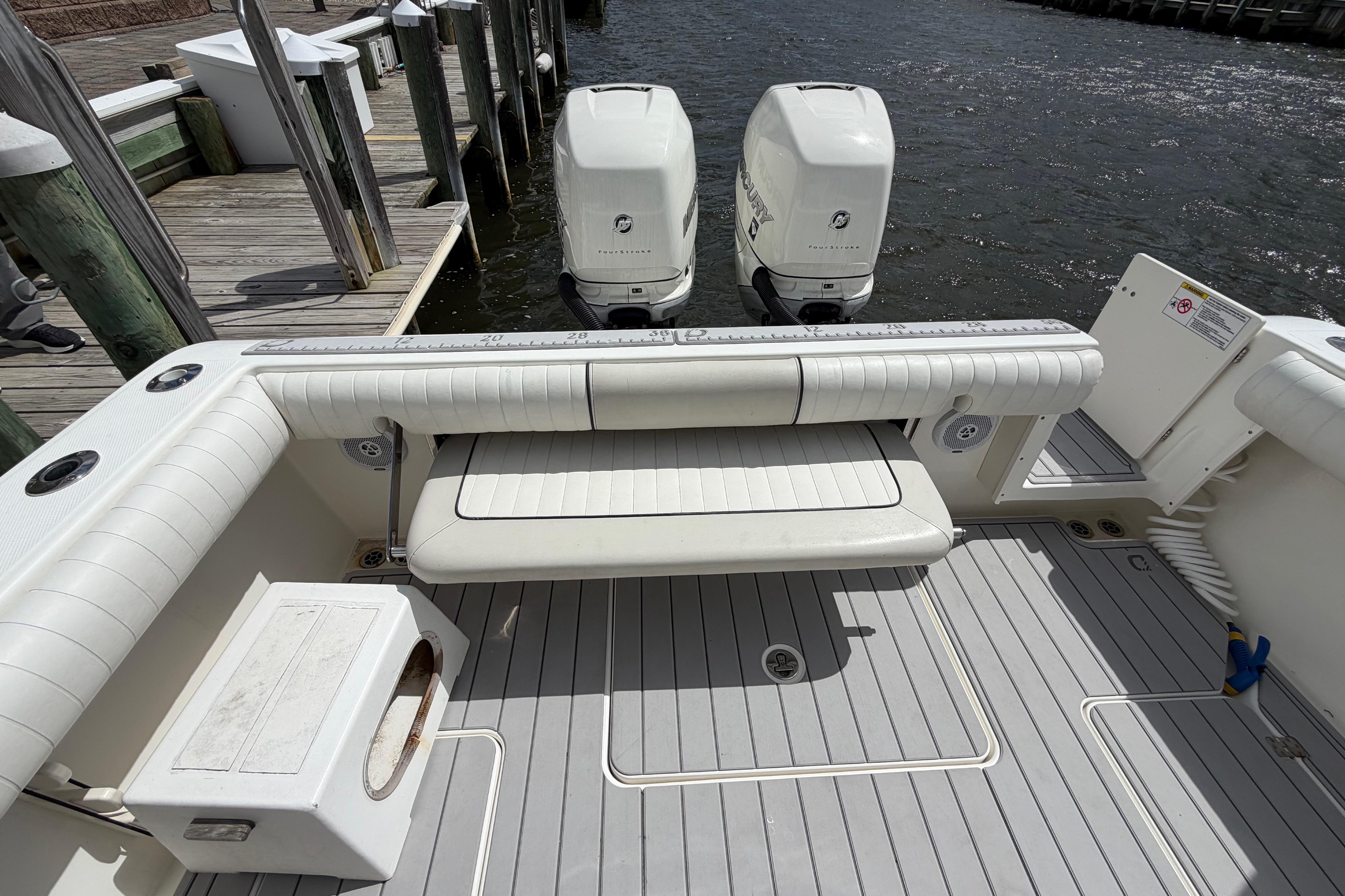 2017 Mako 284 Center Console boat with twin engines docked at a marina.