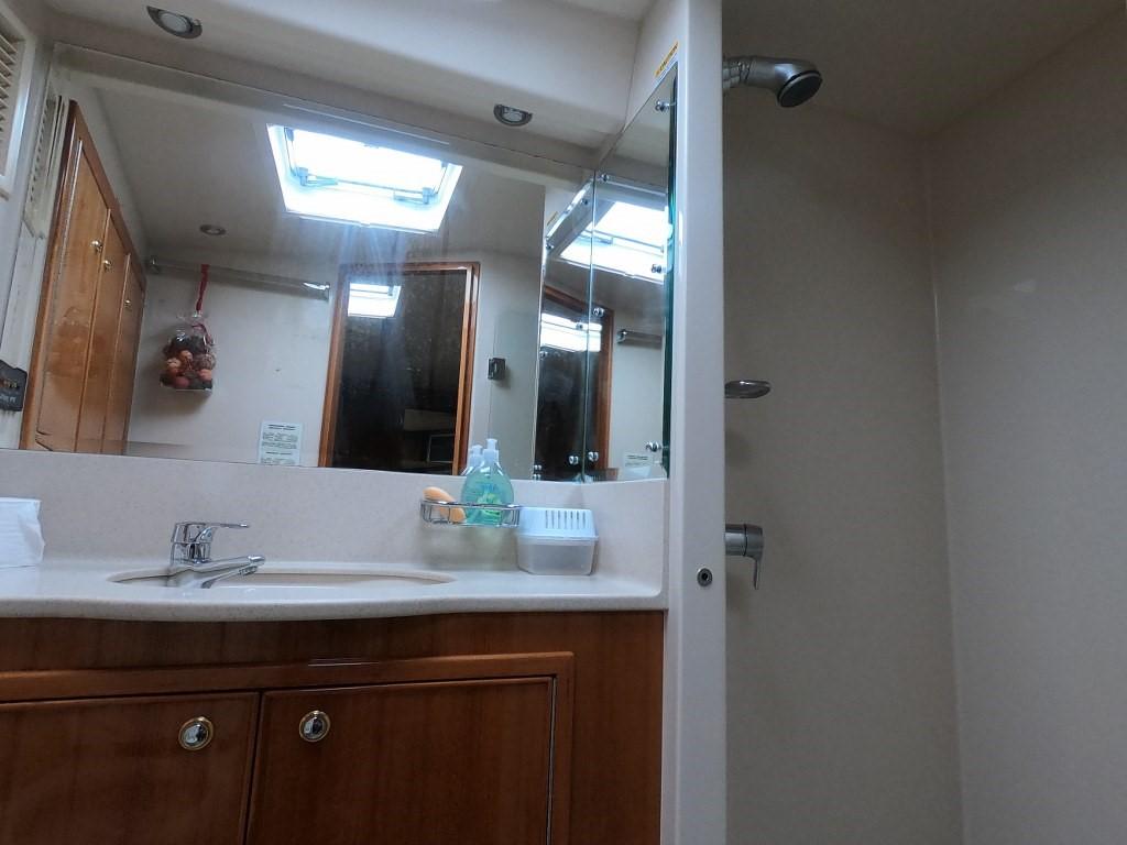 Bathroom interior of 2003 Riviera 58 Convertible yacht with skylight and wooden cabinetry.