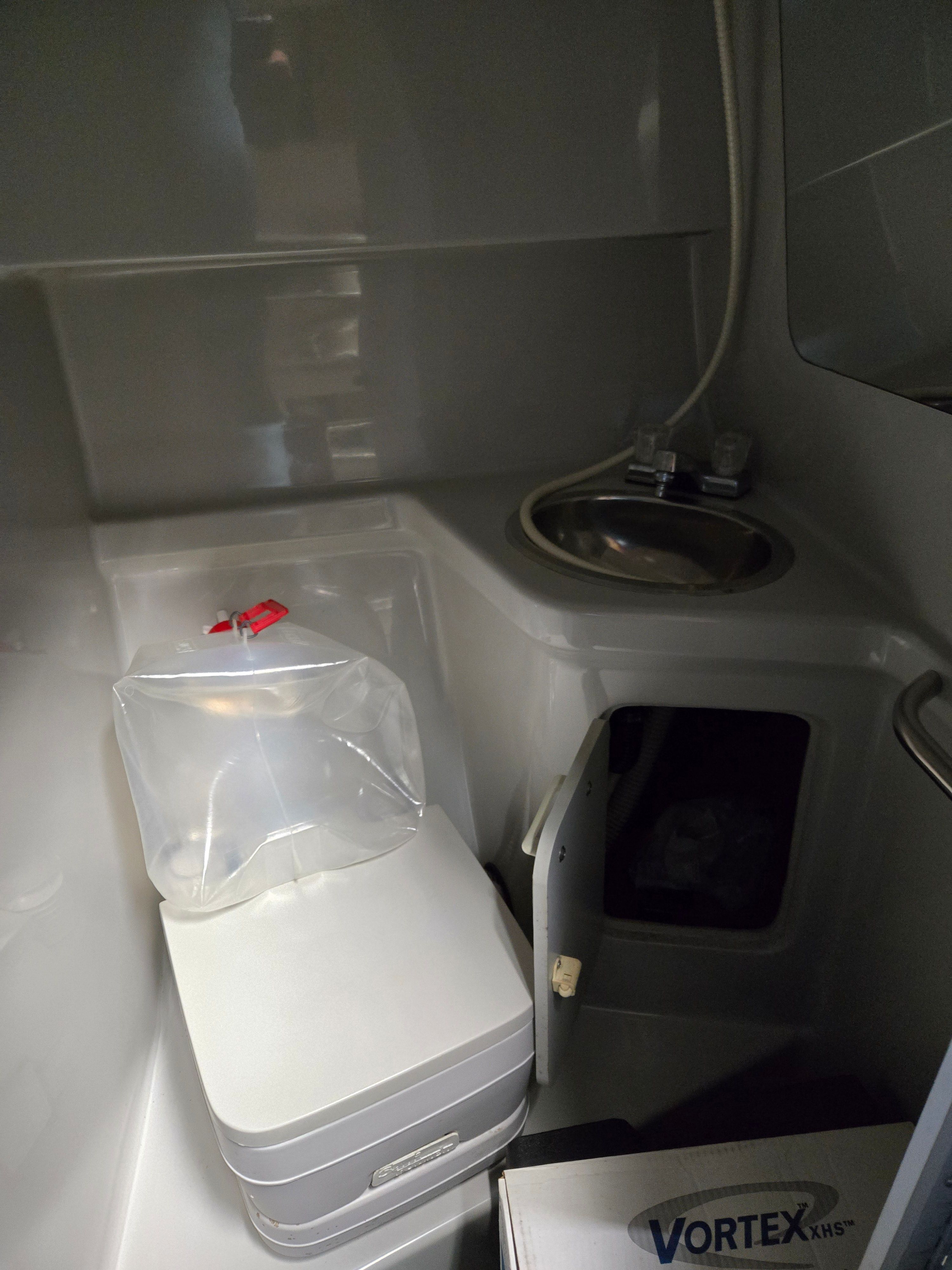 Interior of a 1991 Sea Ray 250 Weekender with a sink and toilet.
