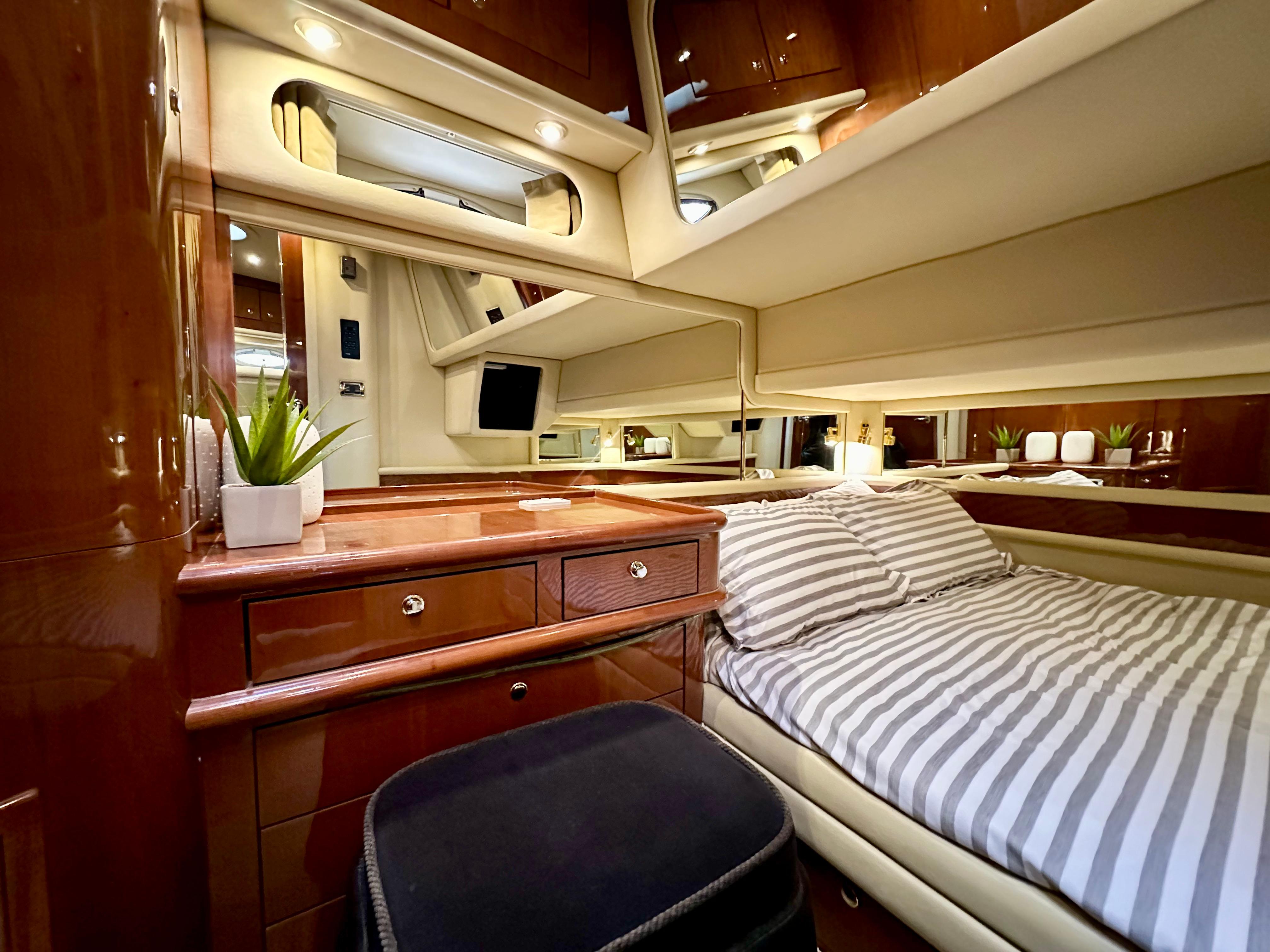 Luxurious cabin interior of 2002 Sea Ray 560 Sedan Bridge yacht with striped bedding.