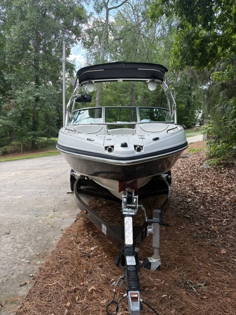 A 2007 Rinker 226 Captiva Bowrider on a trailer, surrounded by trees.