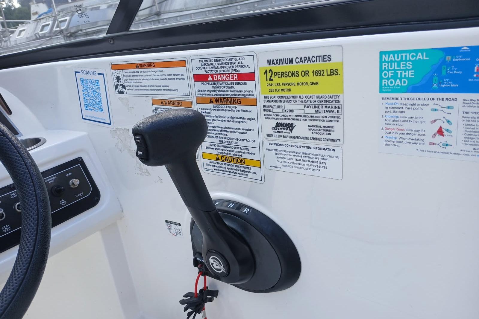 2023 Bayliner DX 2200 boat controls with safety and capacity labels.