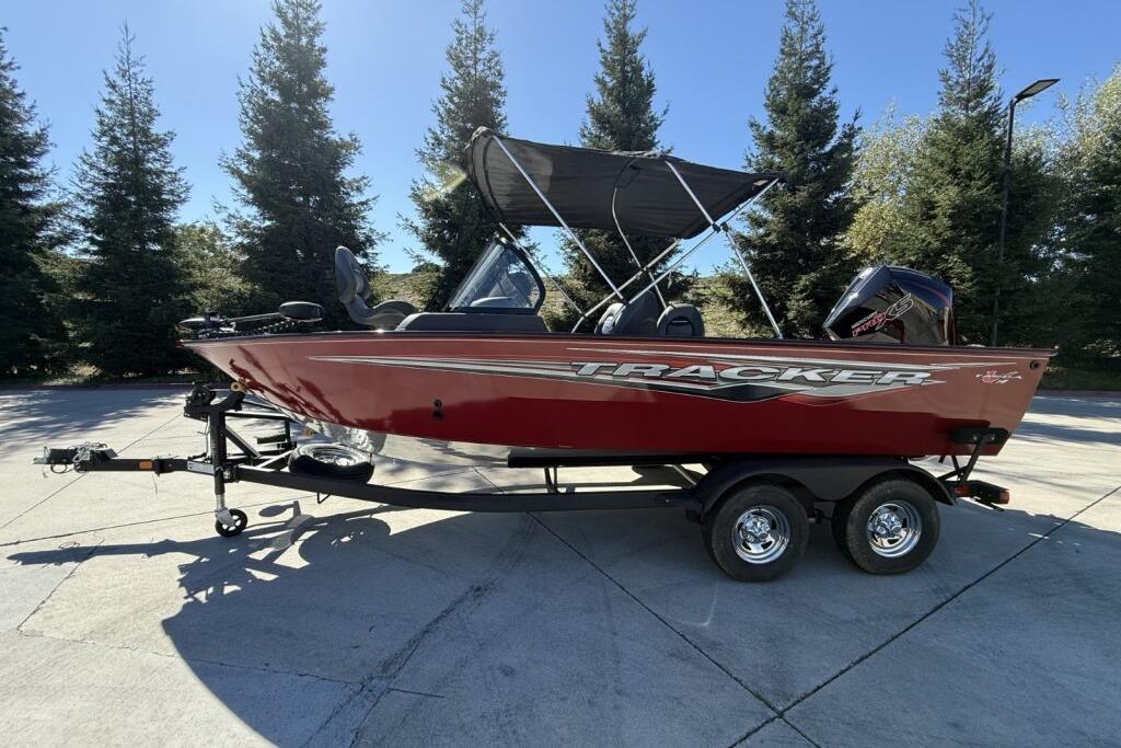 2024 Tracker Targa V-19 WT boat on trailer, parked outdoors with trees in background.