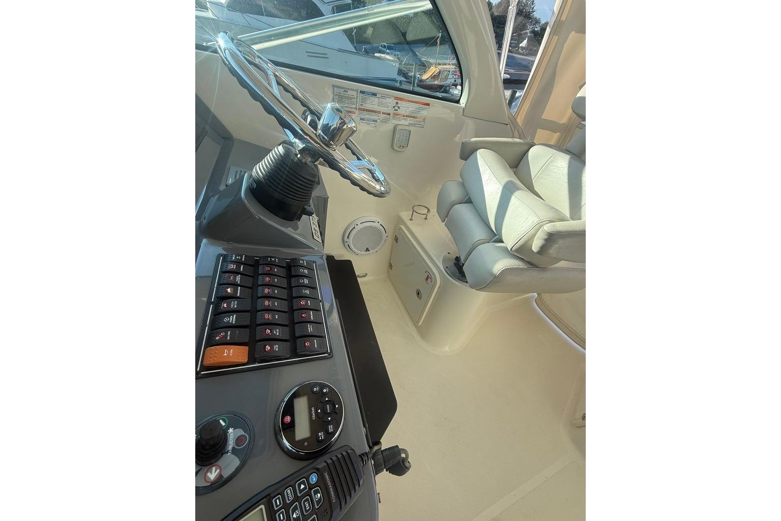 Helm of 2010 Pursuit OS 375 Offshore boat with steering wheel and control panel.