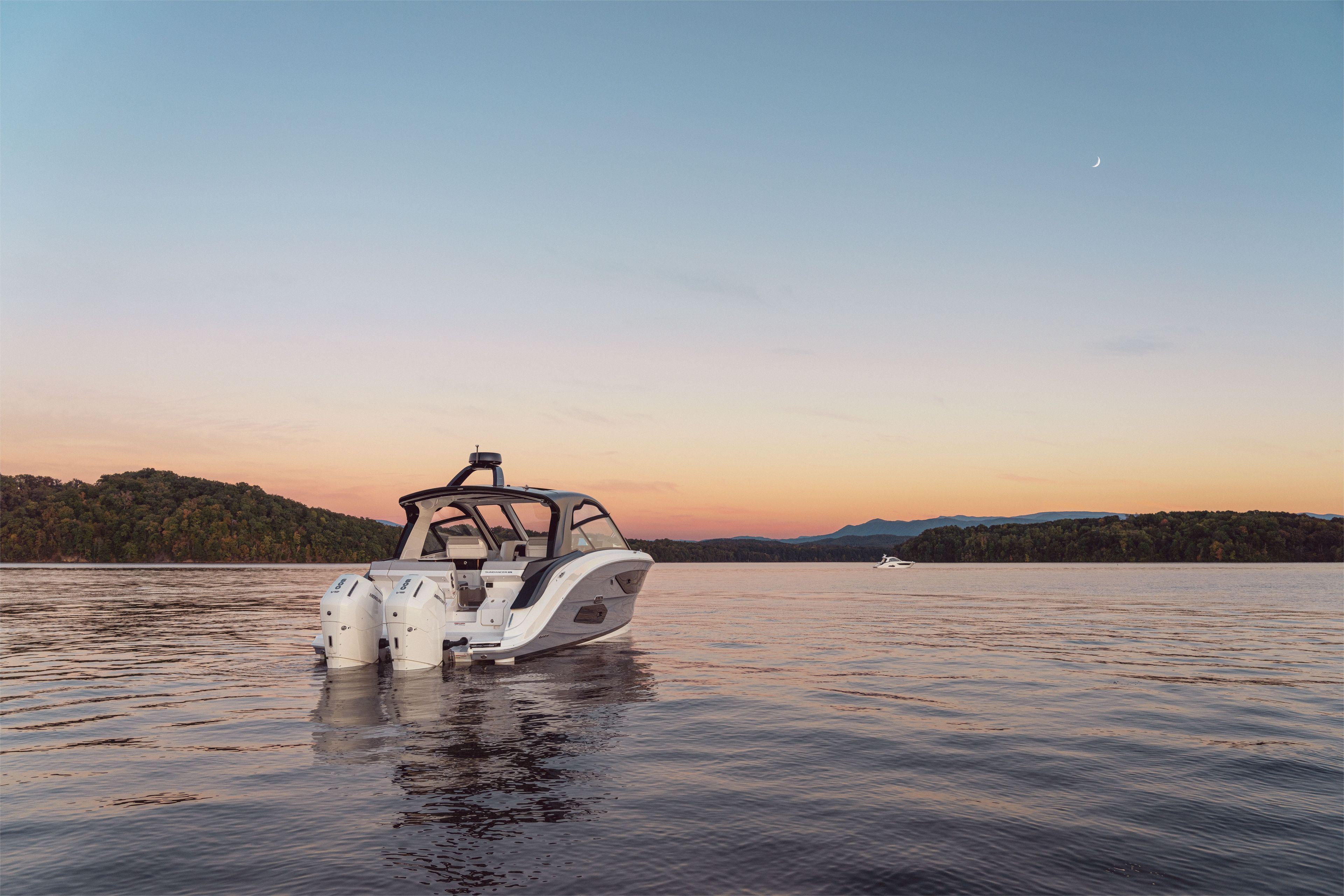 Sea Ray Sundancer 370 Outboard on calm water at sunset.