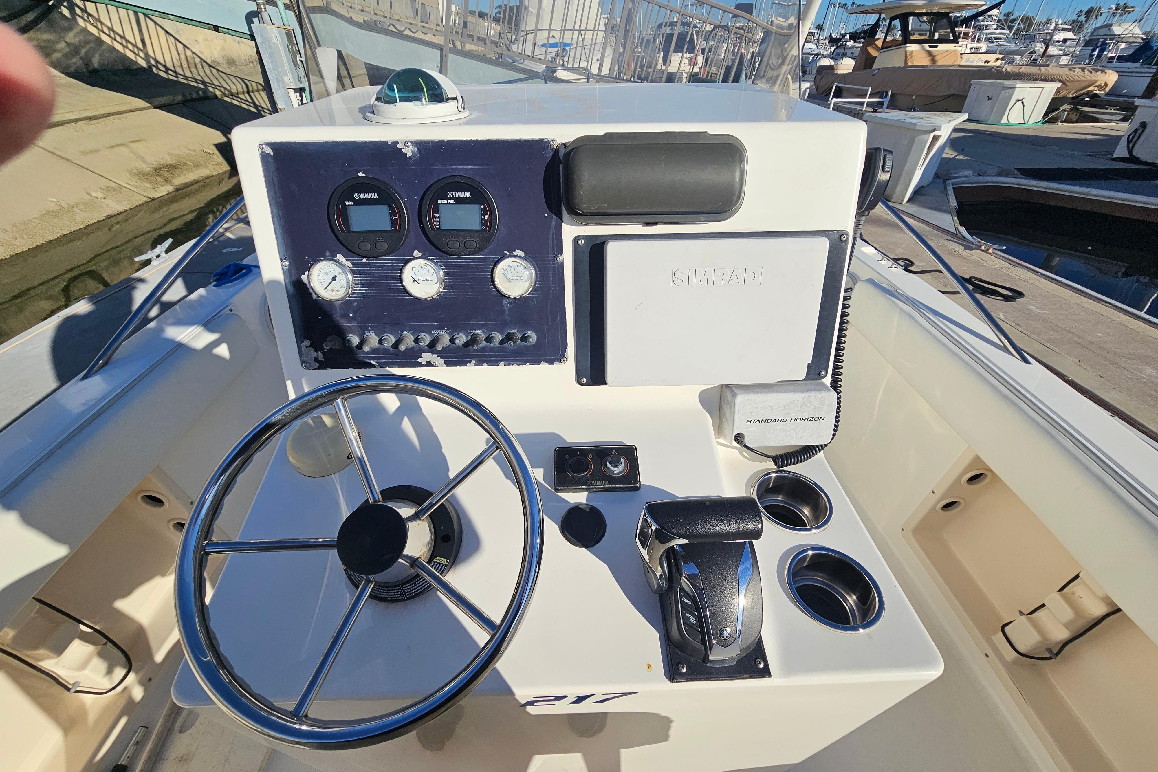 2002 Sea Fox 210 Center Console boat dashboard with steering wheel and navigation instruments.