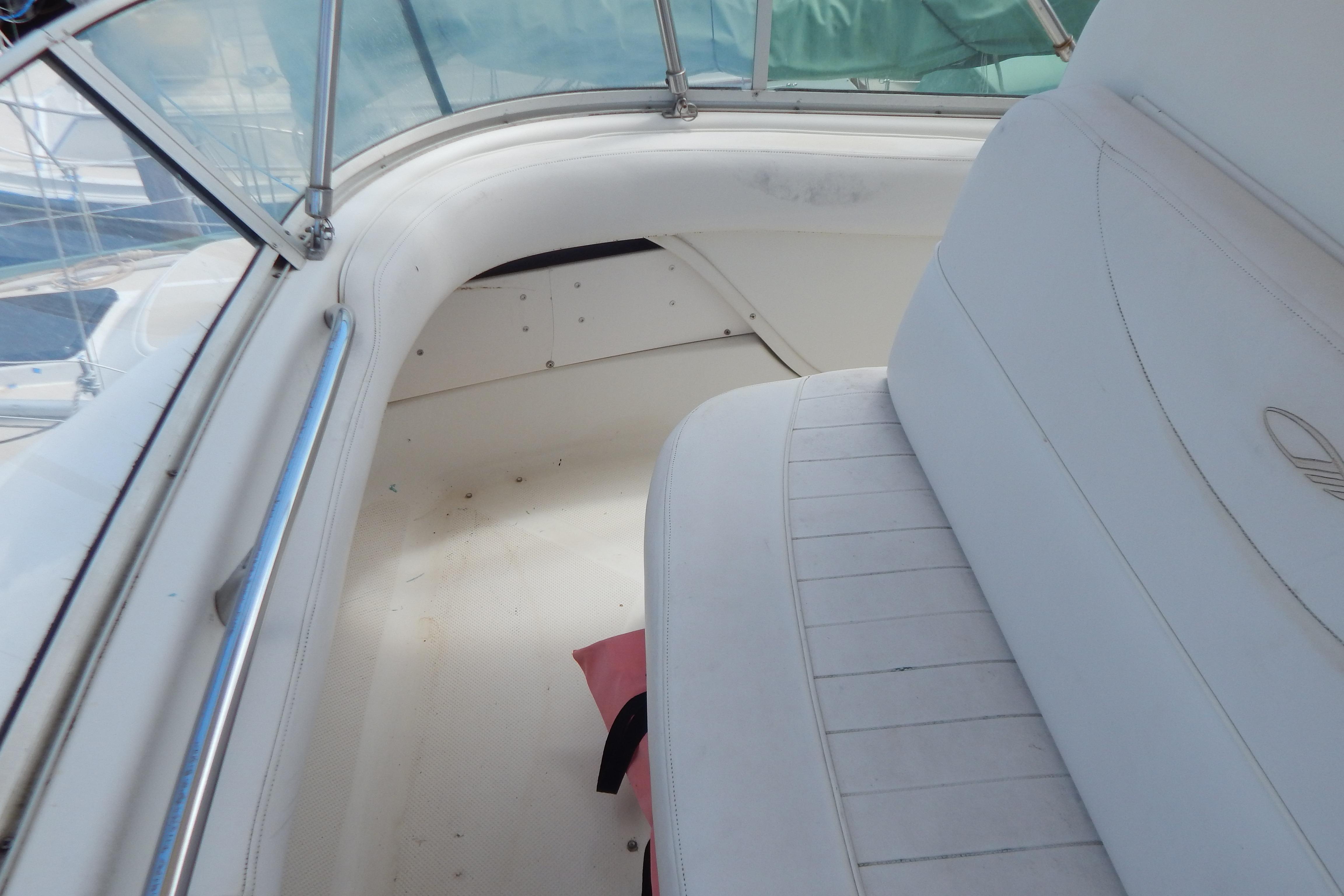 Interior view of a 1998 Magnum 4100 SCR boat, featuring white seating and railing.