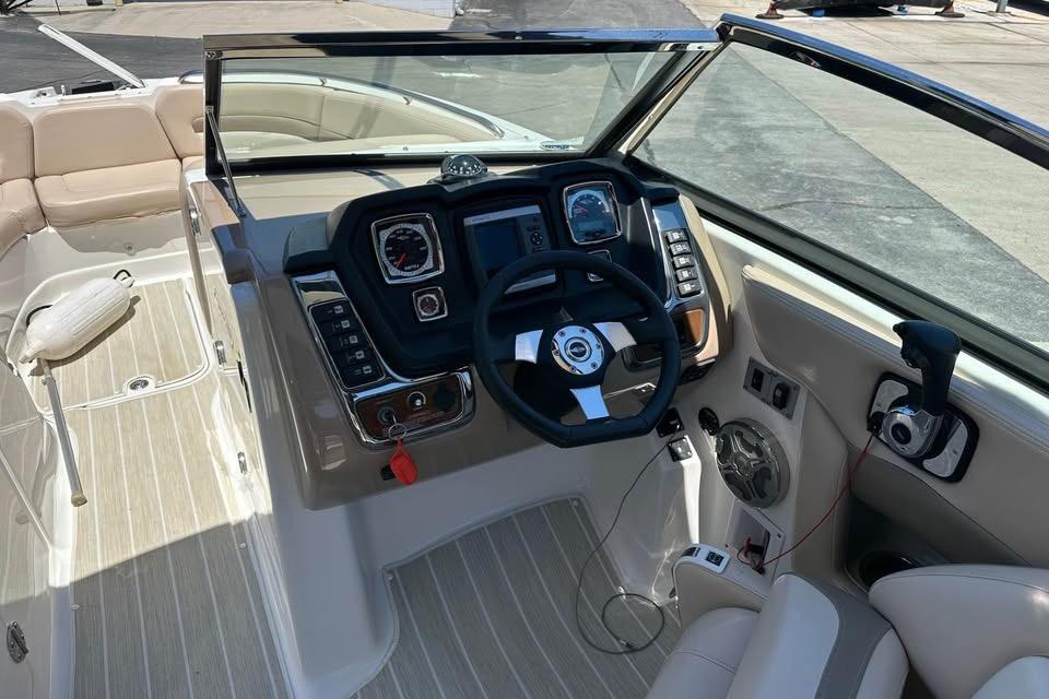 2012 Chaparral 284 Sunesta boat cockpit with steering wheel and control panel.