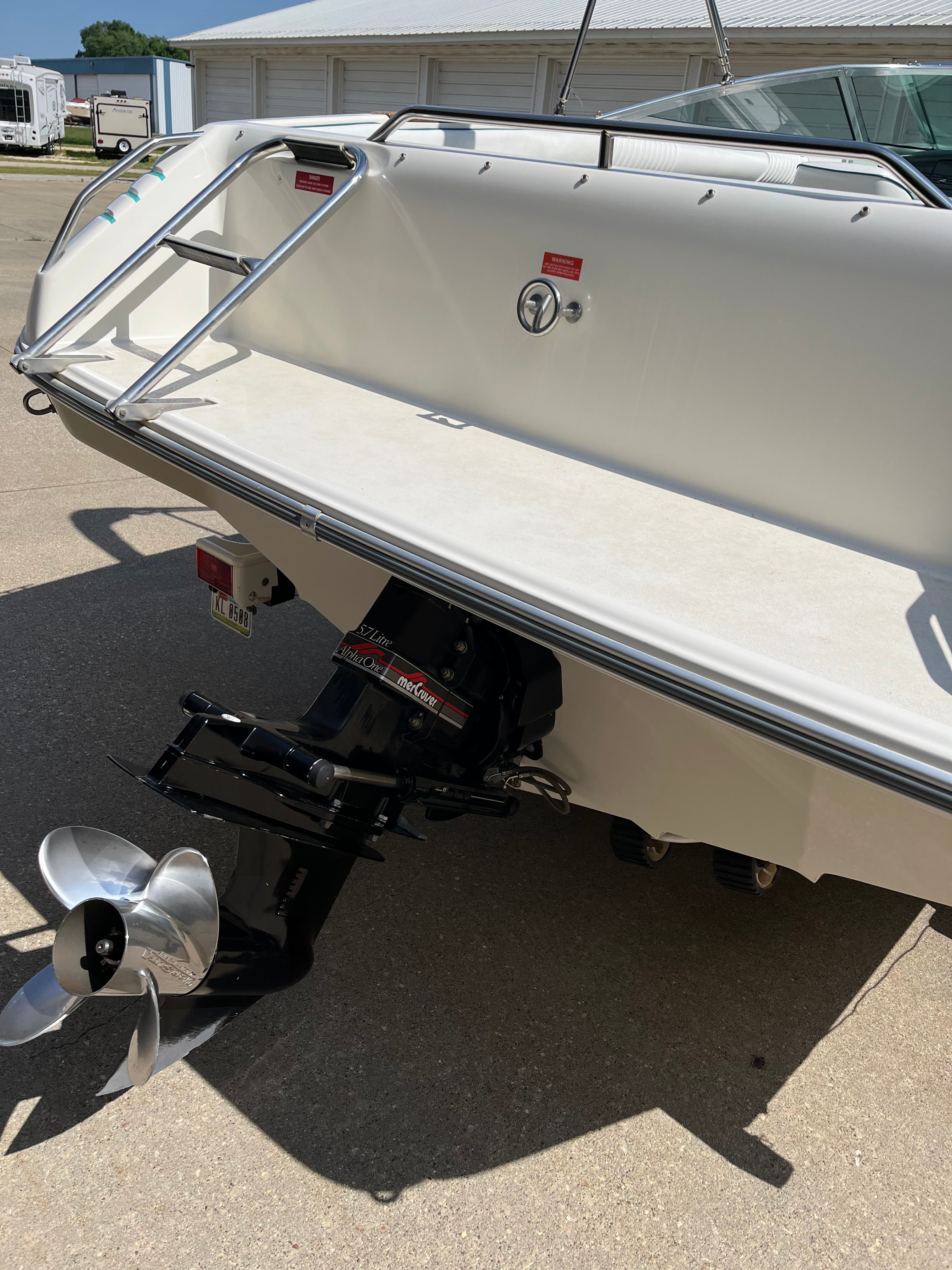 A Sea Ray 220 Bow Rider boat on a trailer, featuring an outboard motor.