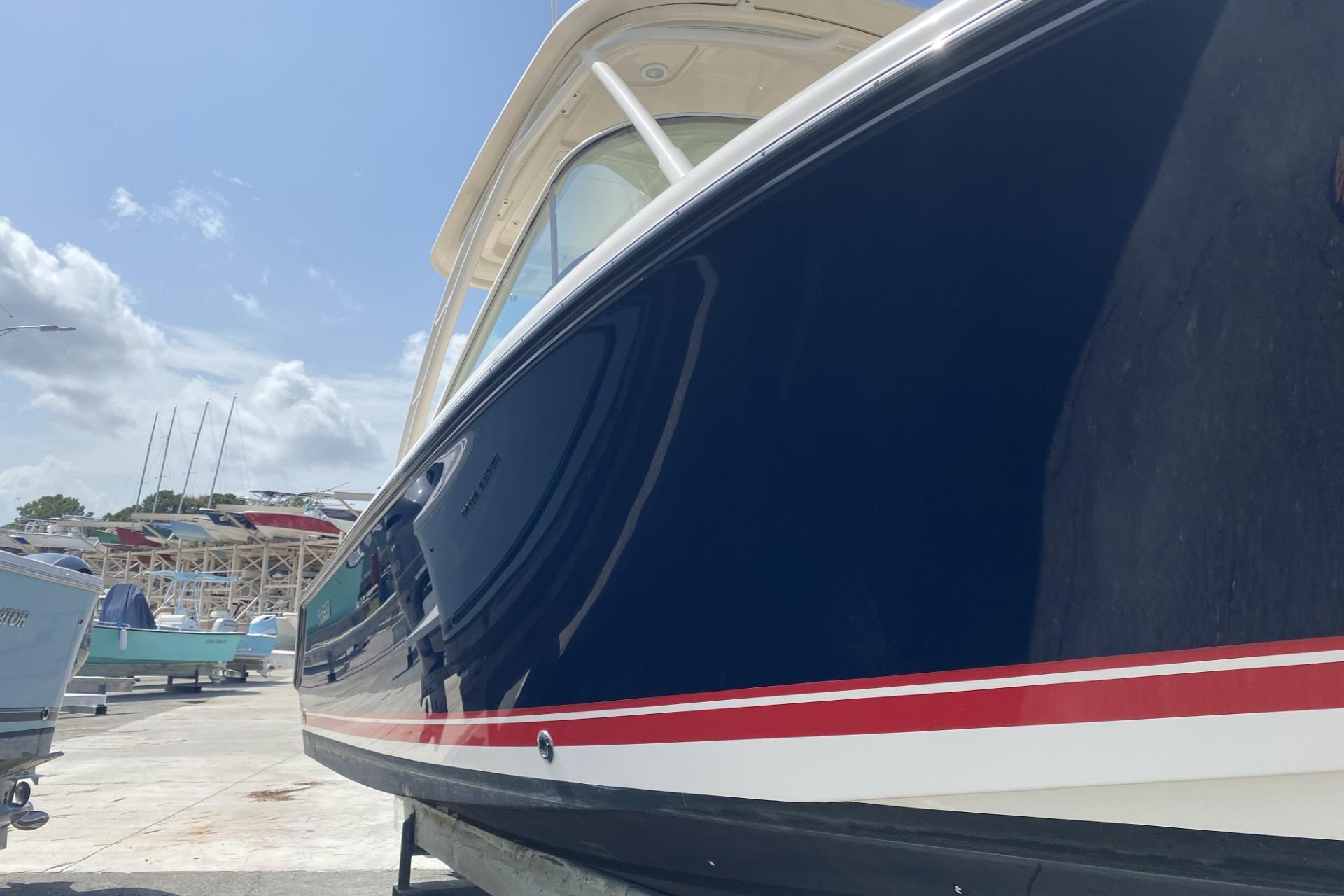 2013 Pursuit DC 265 Dual Console boat with sleek blue hull and red stripe.