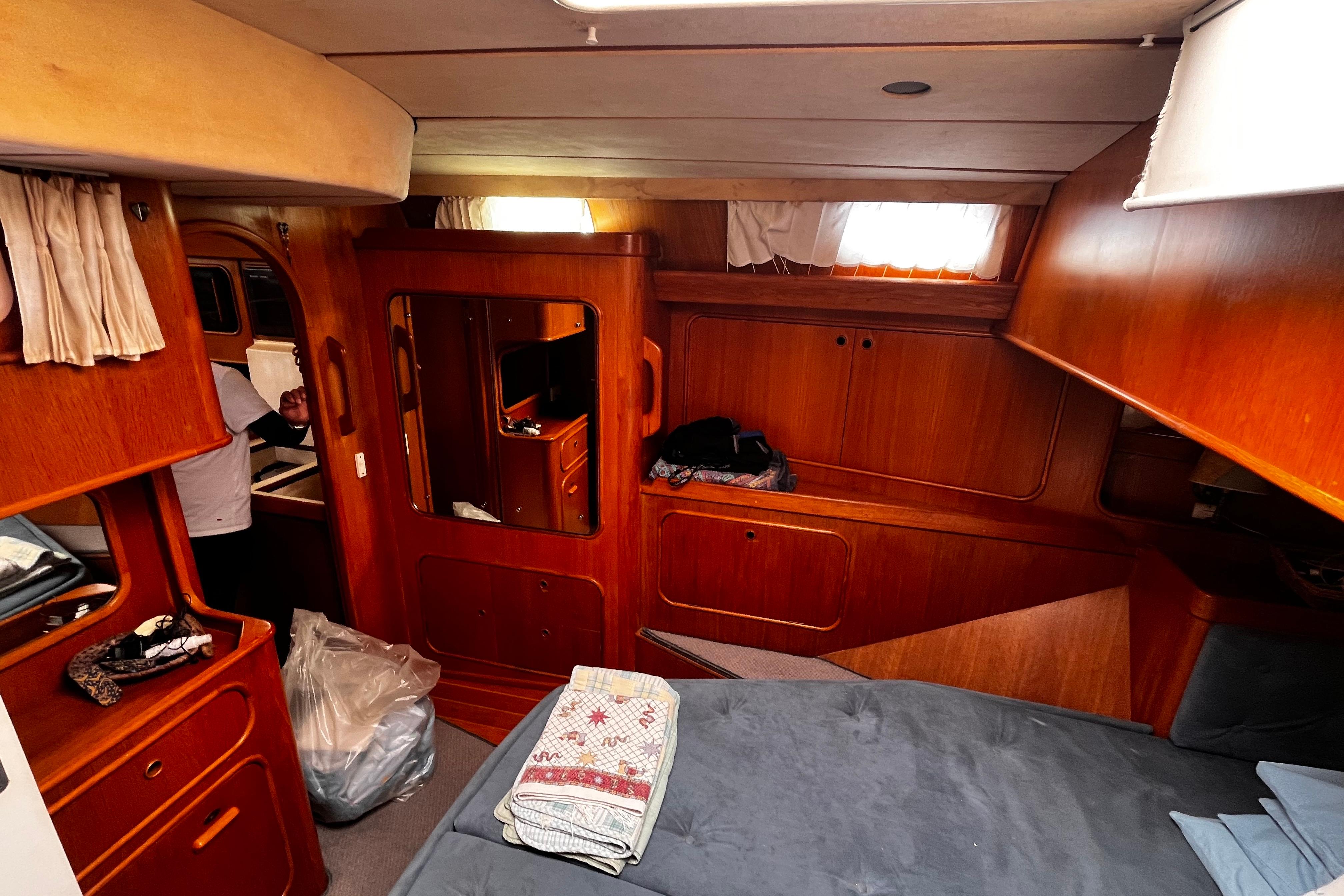 Interior of 1989 Oyster 53 Deck Saloon yacht, featuring wooden cabinetry and cozy sleeping area.