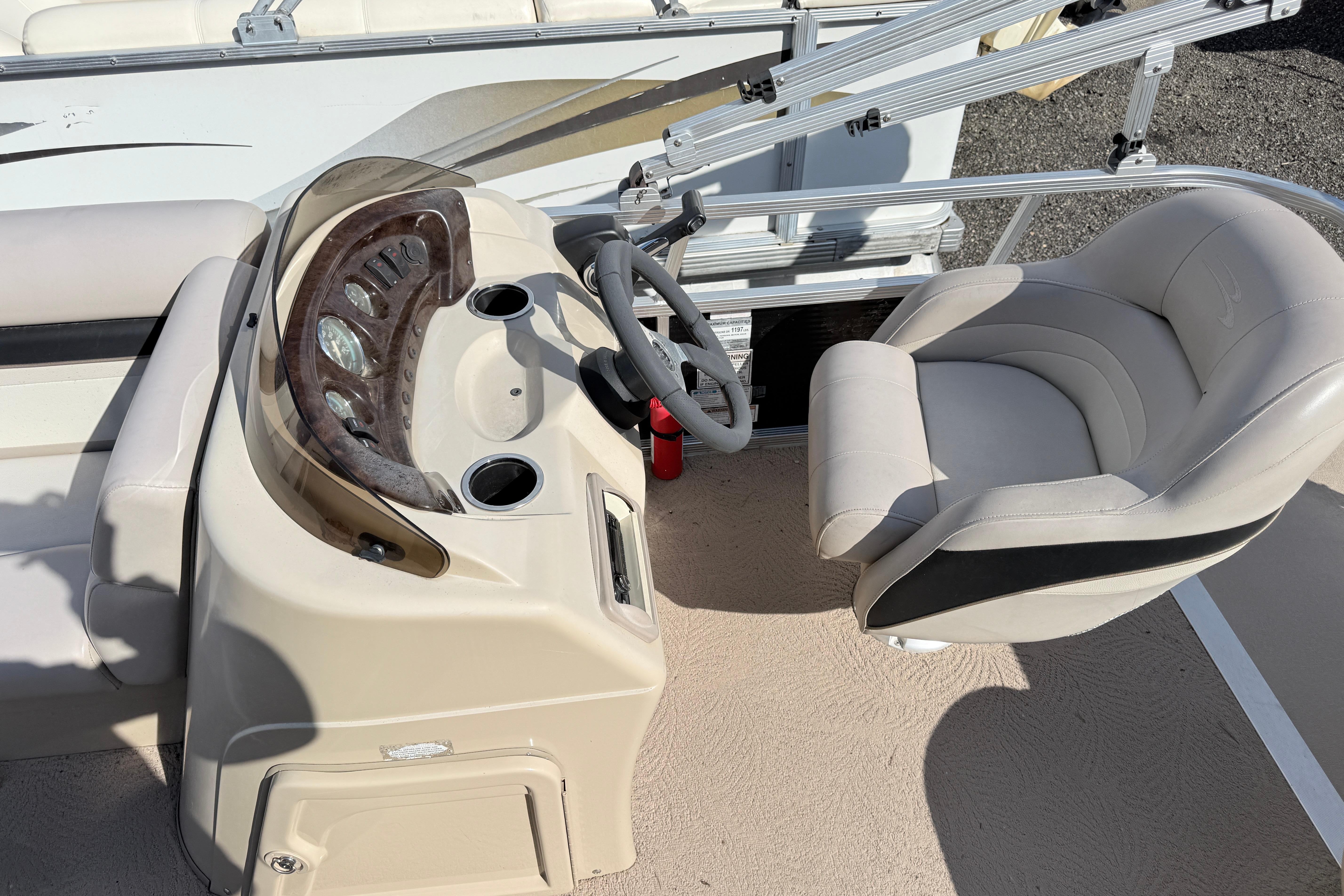 Captain's seat and helm of a 2010 Bennington 20SLi pontoon boat, featuring a sleek dashboard.