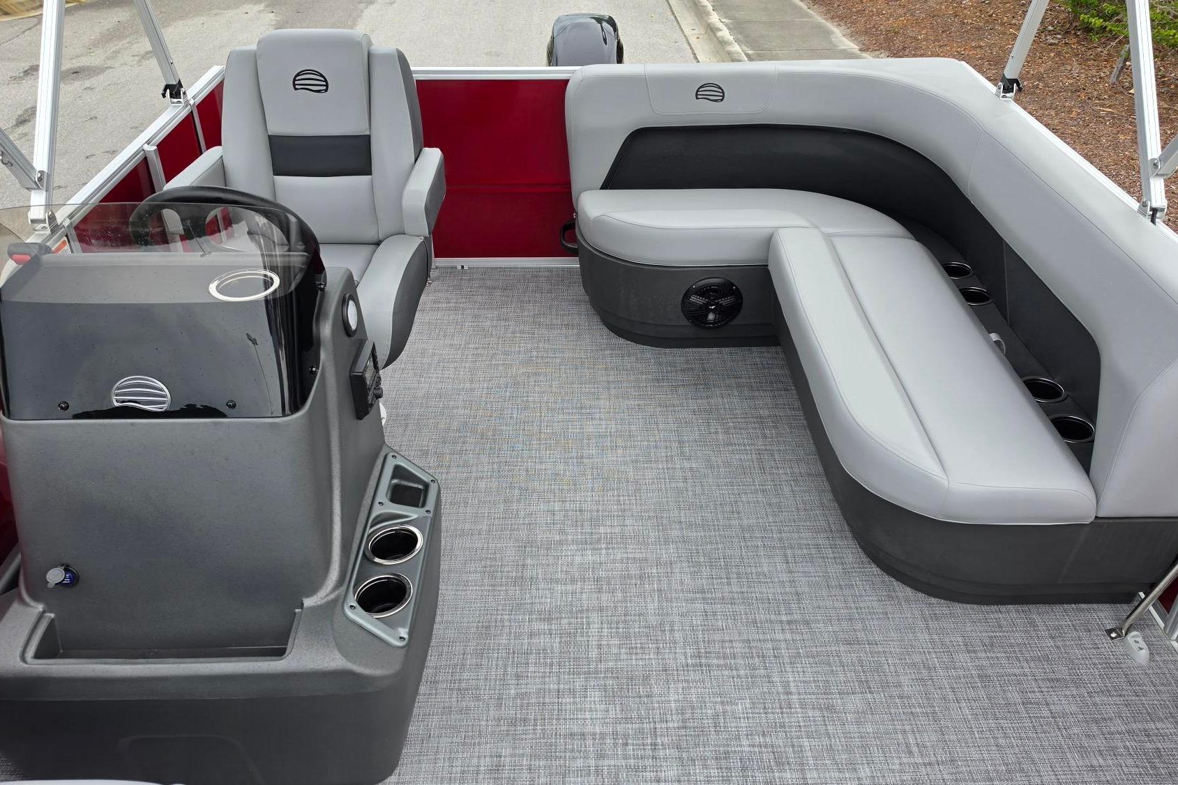 2026 Sun Tracker Party Barge 16 DLX interior with gray seating and helm.