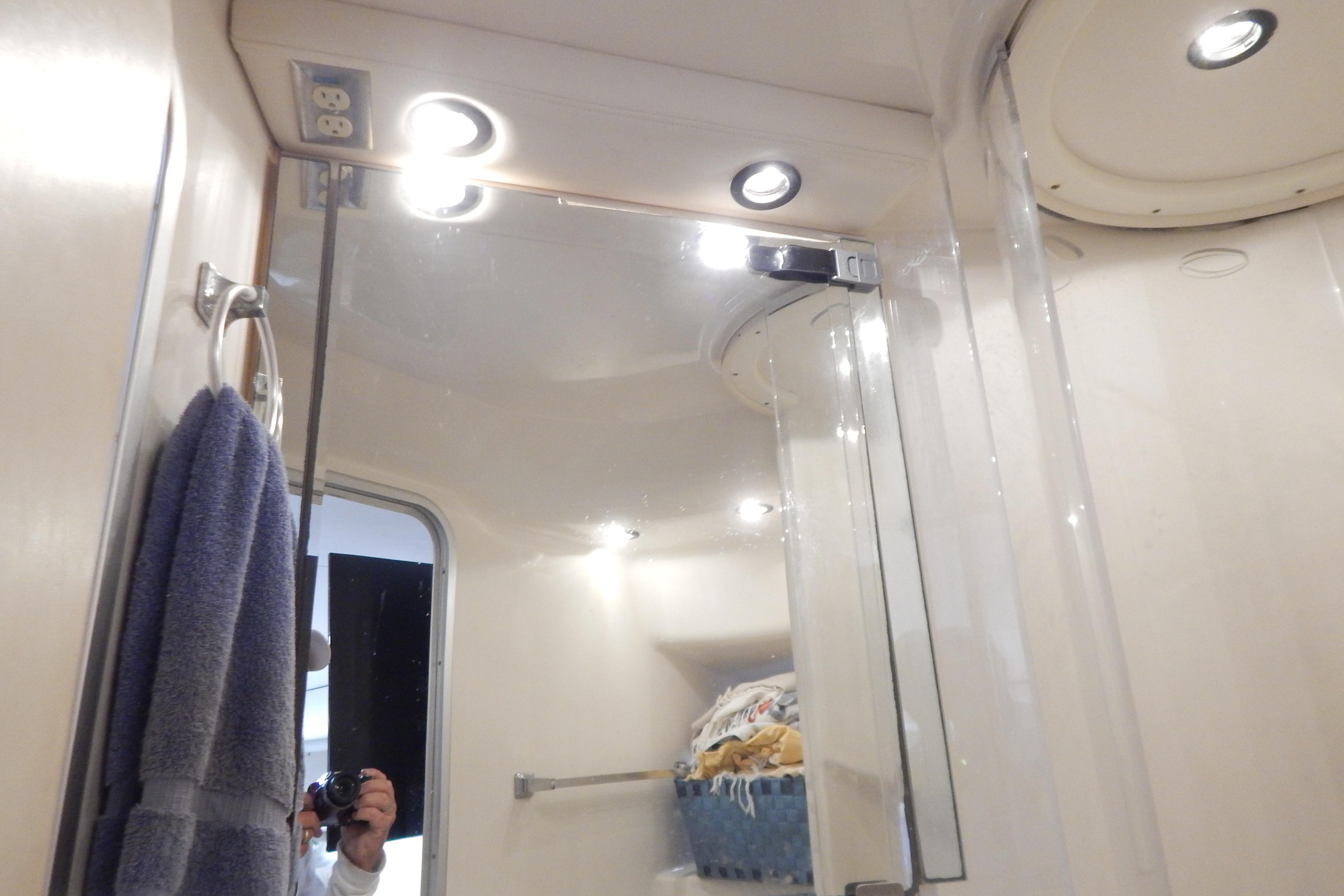 Bathroom interior of 1998 Magnum 4100 SCR with mirror, towel, and lighting.