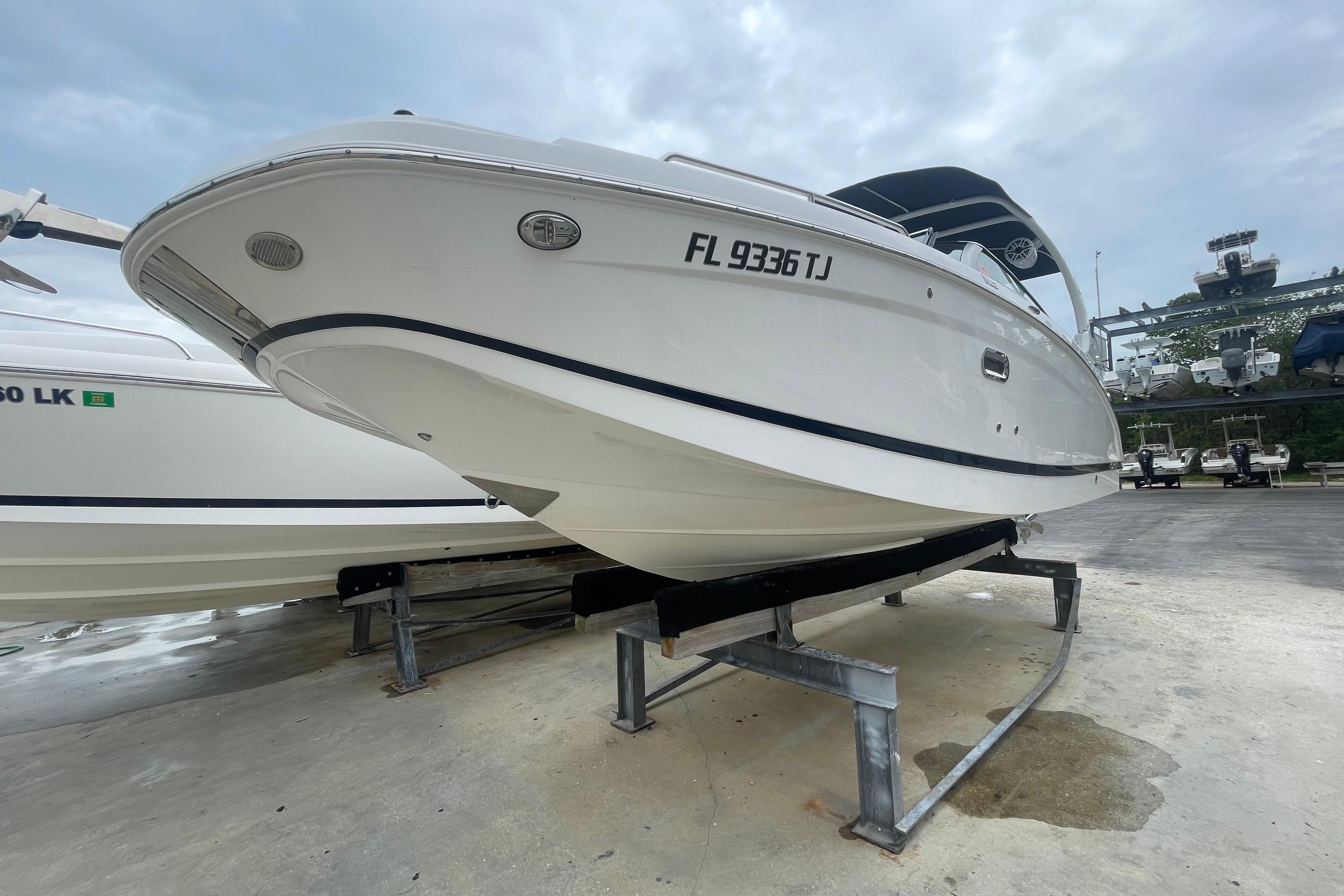 2022 Four Winns HD8 OB boat on display, elevated on a stand, with overcast sky.
