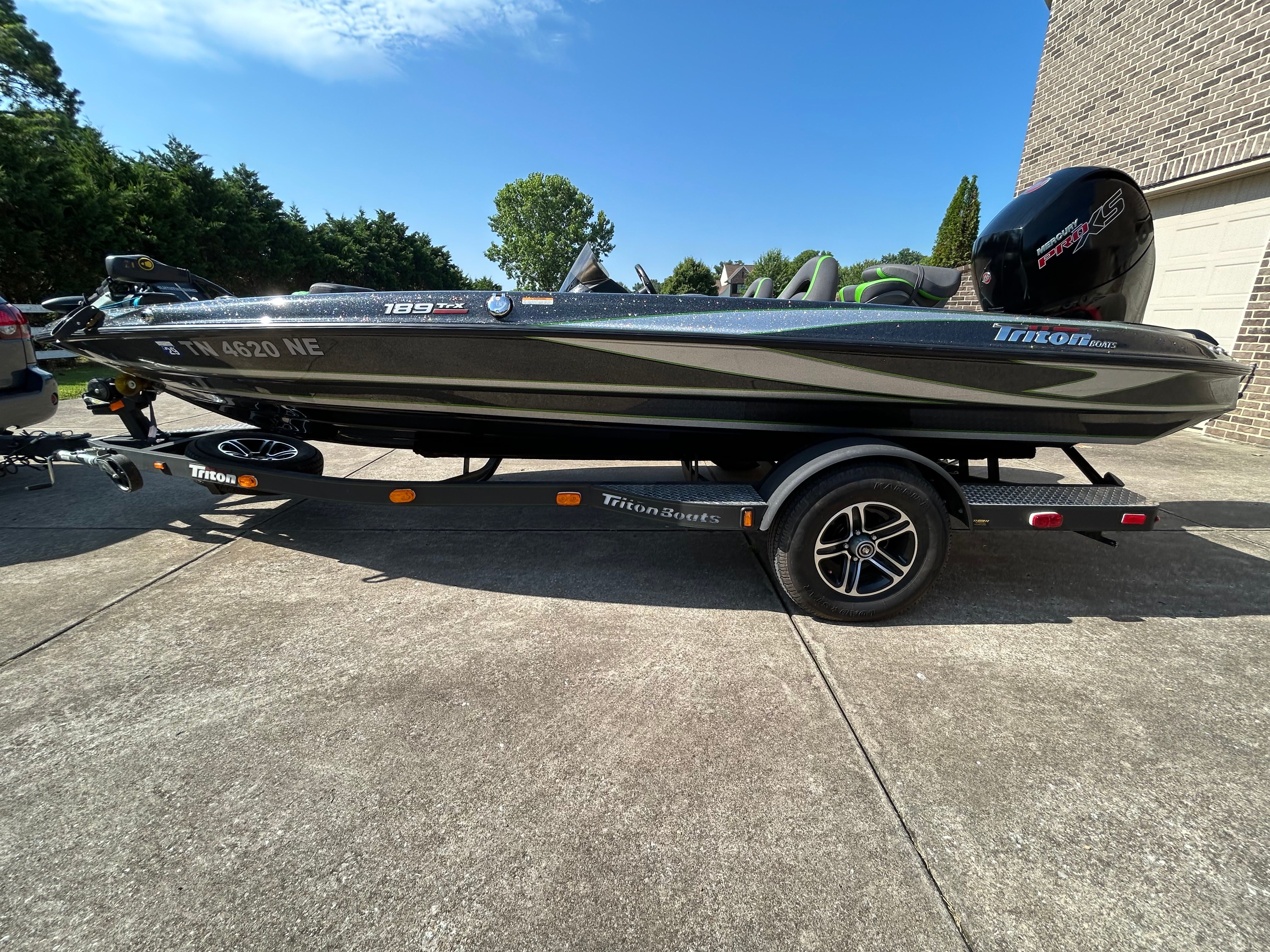 A 2020 Trident 189 TRX boat on a trailer, parked in a driveway.