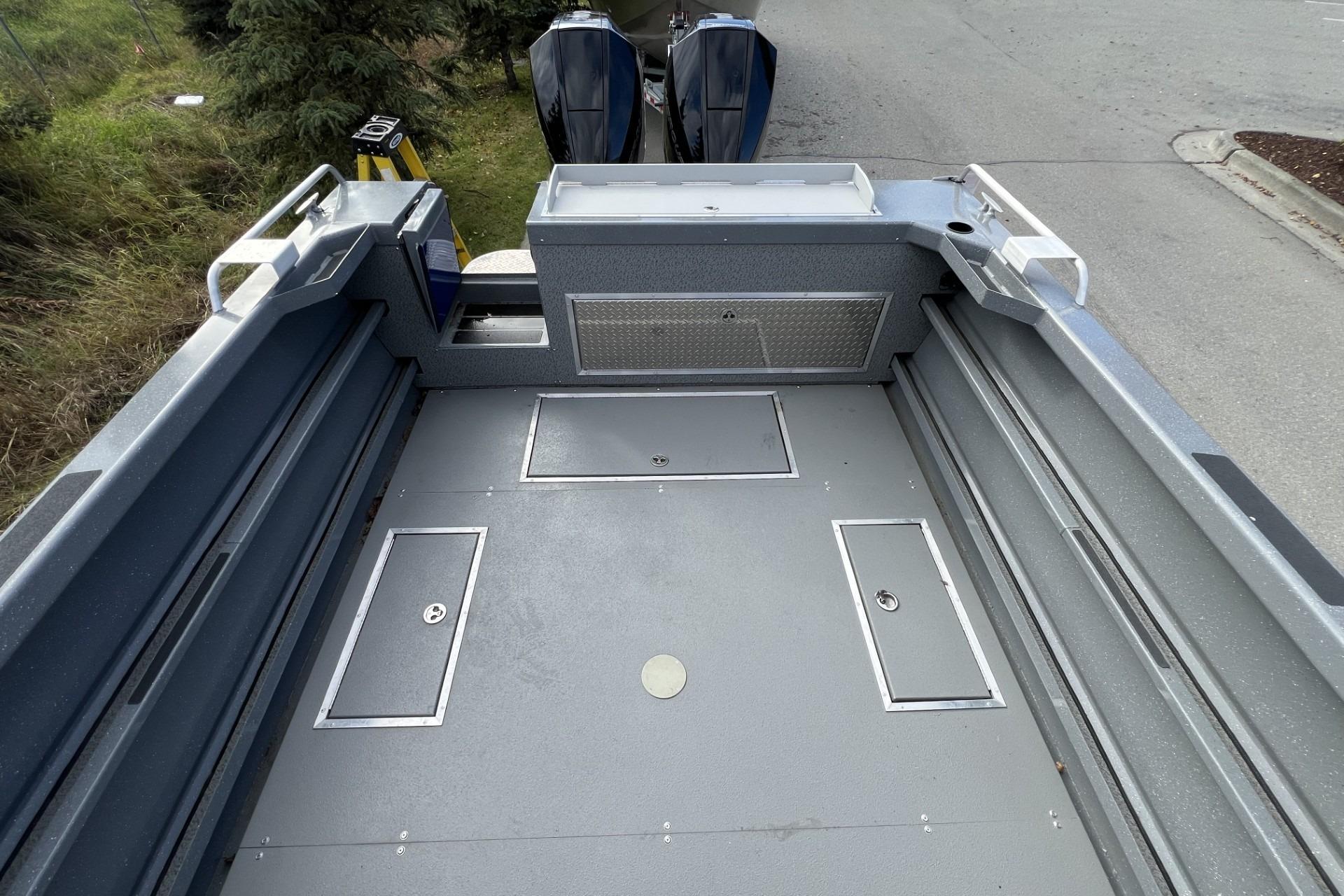 2024 Spartan 26 Maximus Pro XL boat deck with storage compartments and dual engines.