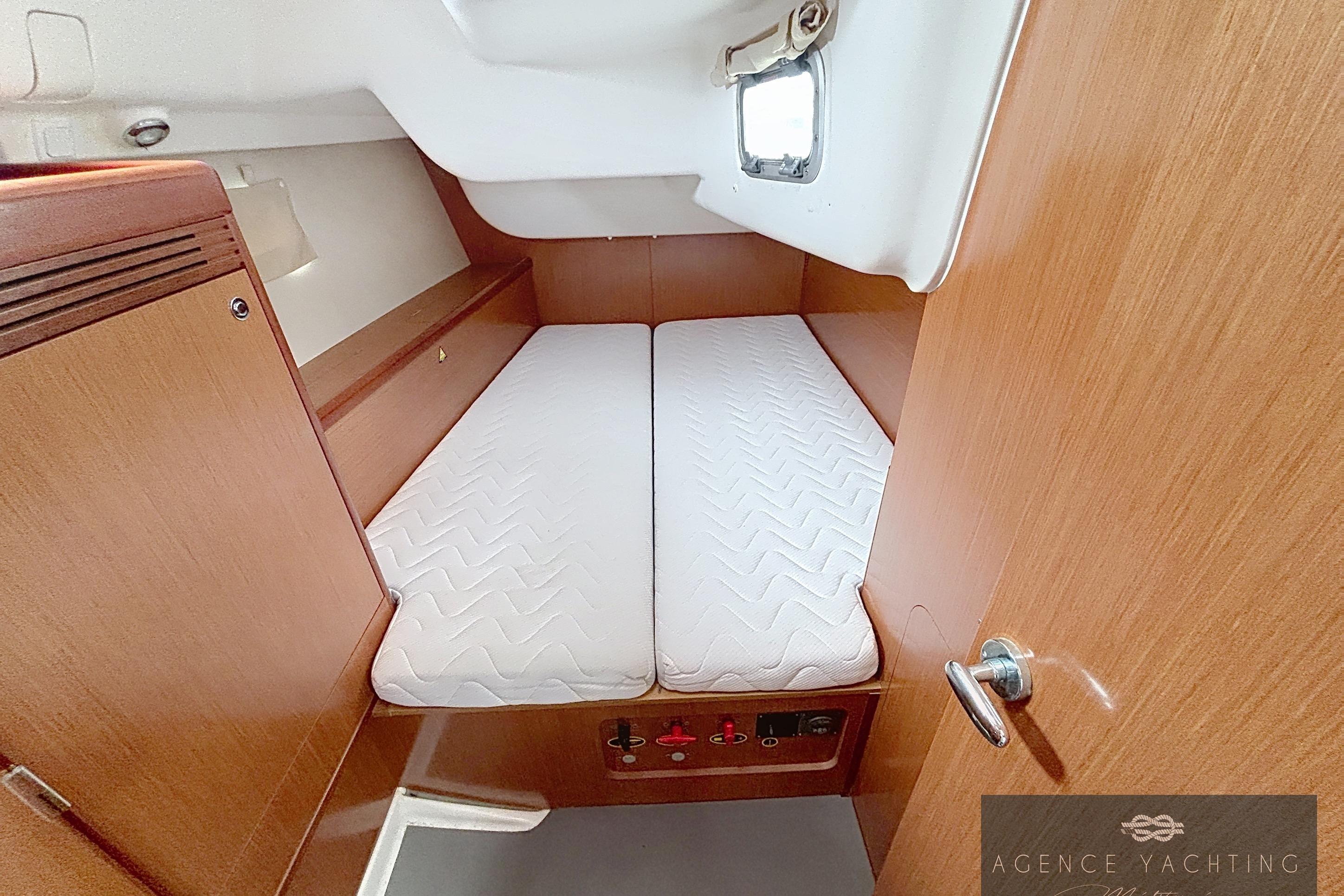 2008 Beneteau Oceanis 40 cabin with twin beds, wooden interior, and porthole window.