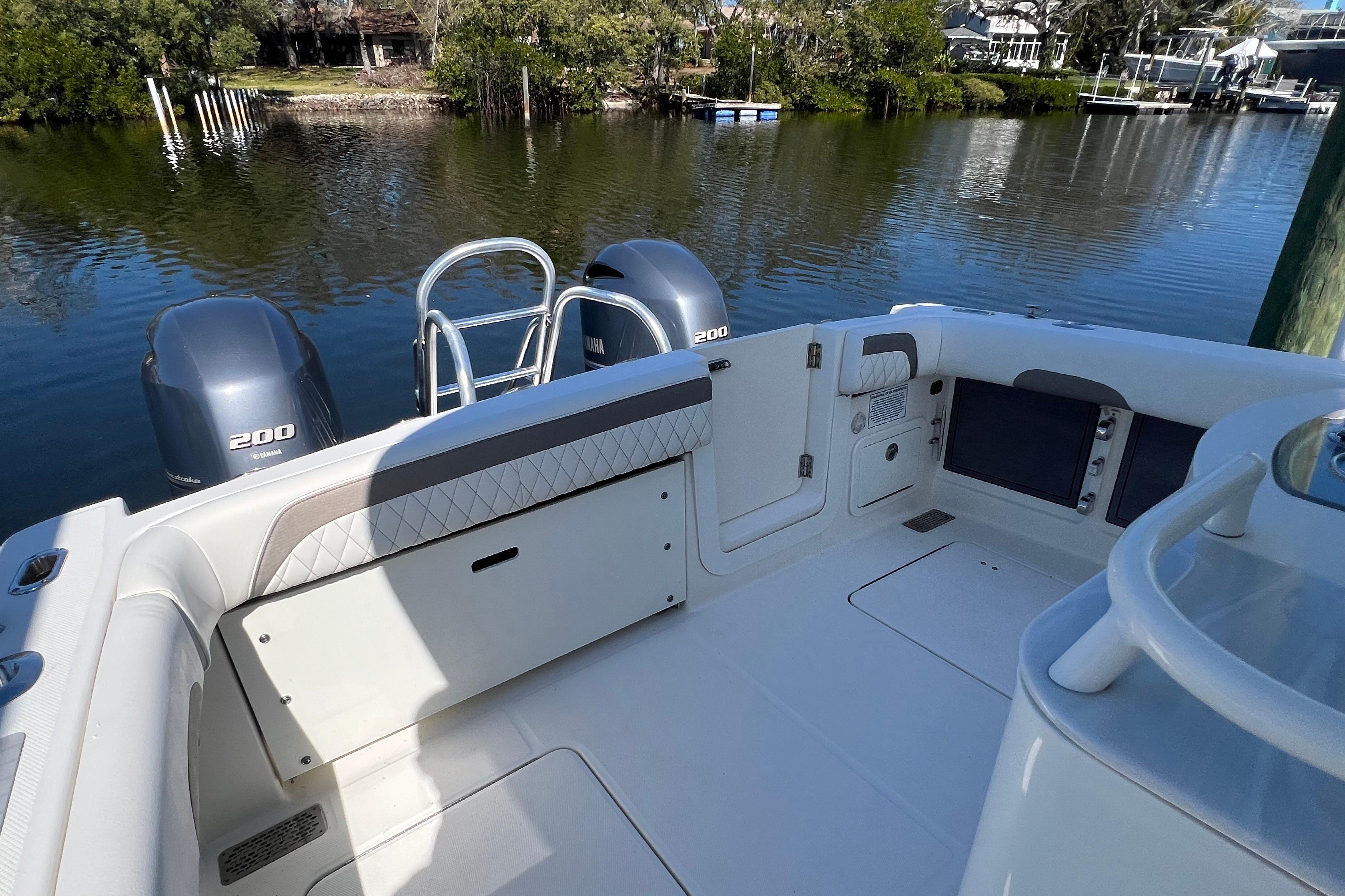 2022 World Cat 280 CC-X boat interior with Yamaha 200 engines, docked by a serene waterfront.