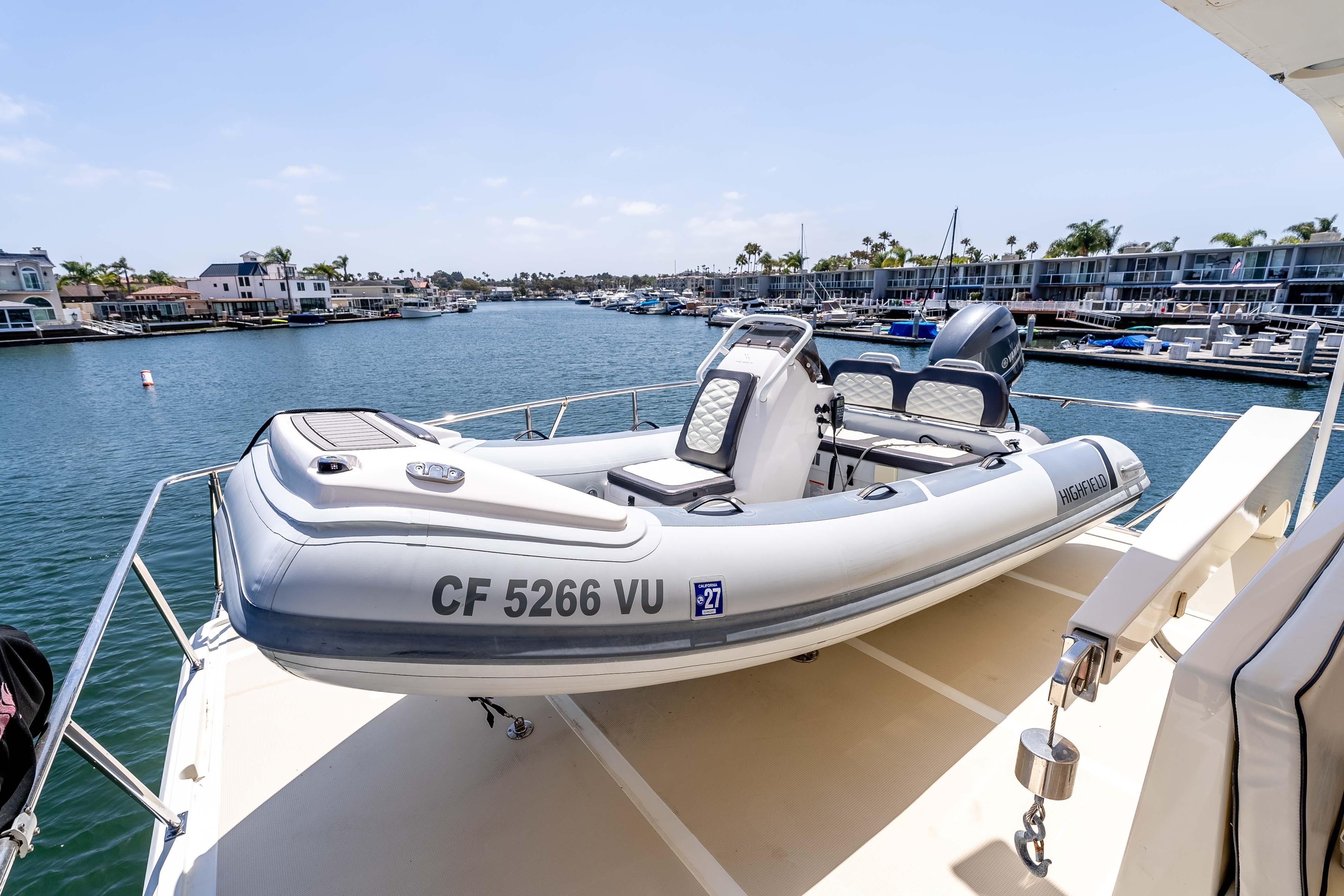 2005 Offshore Yachts 54 Pilothouse with inflatable boat on deck, docked in marina.