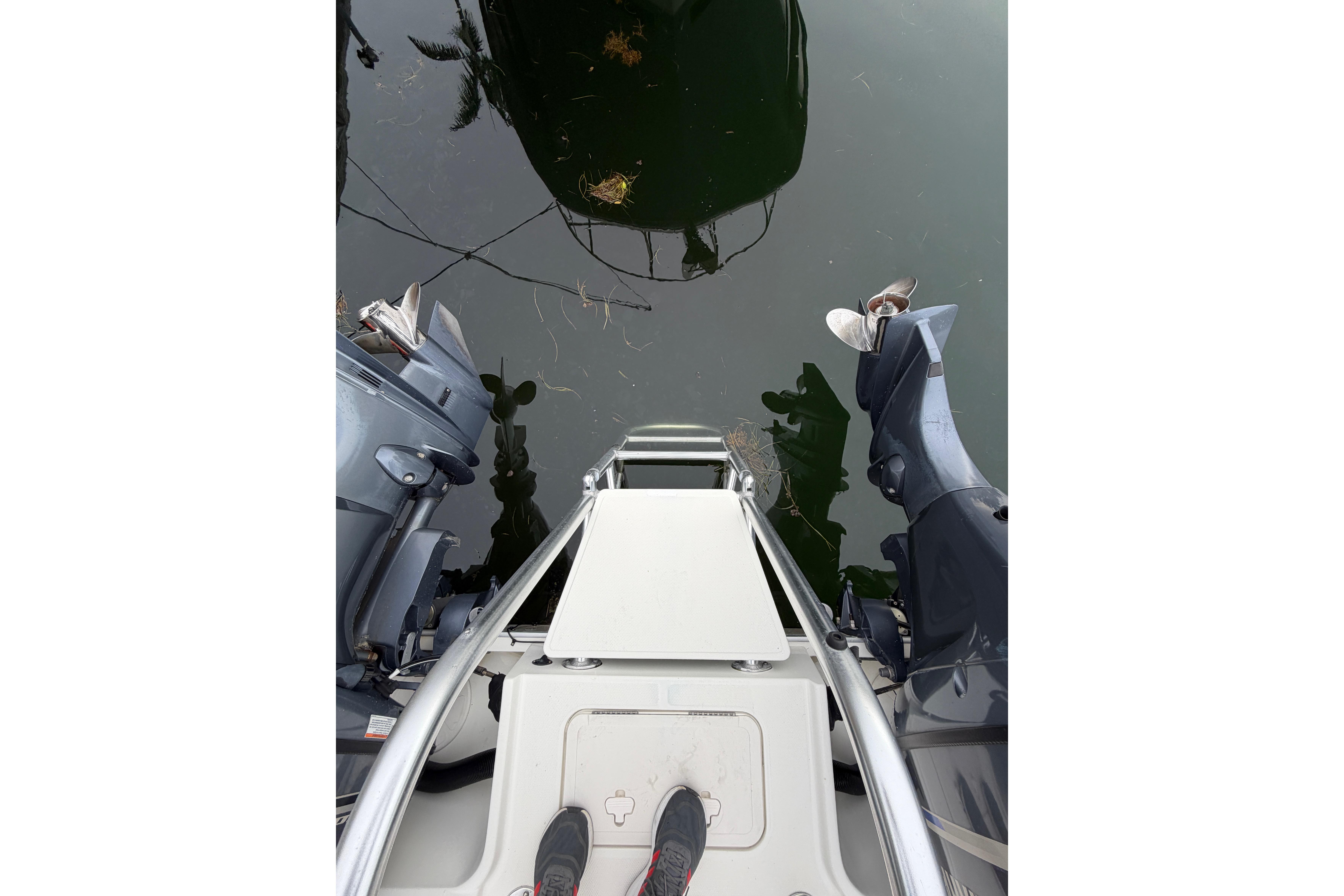 2019 World Cat 230 DC boat stern view with dual outboard motors.