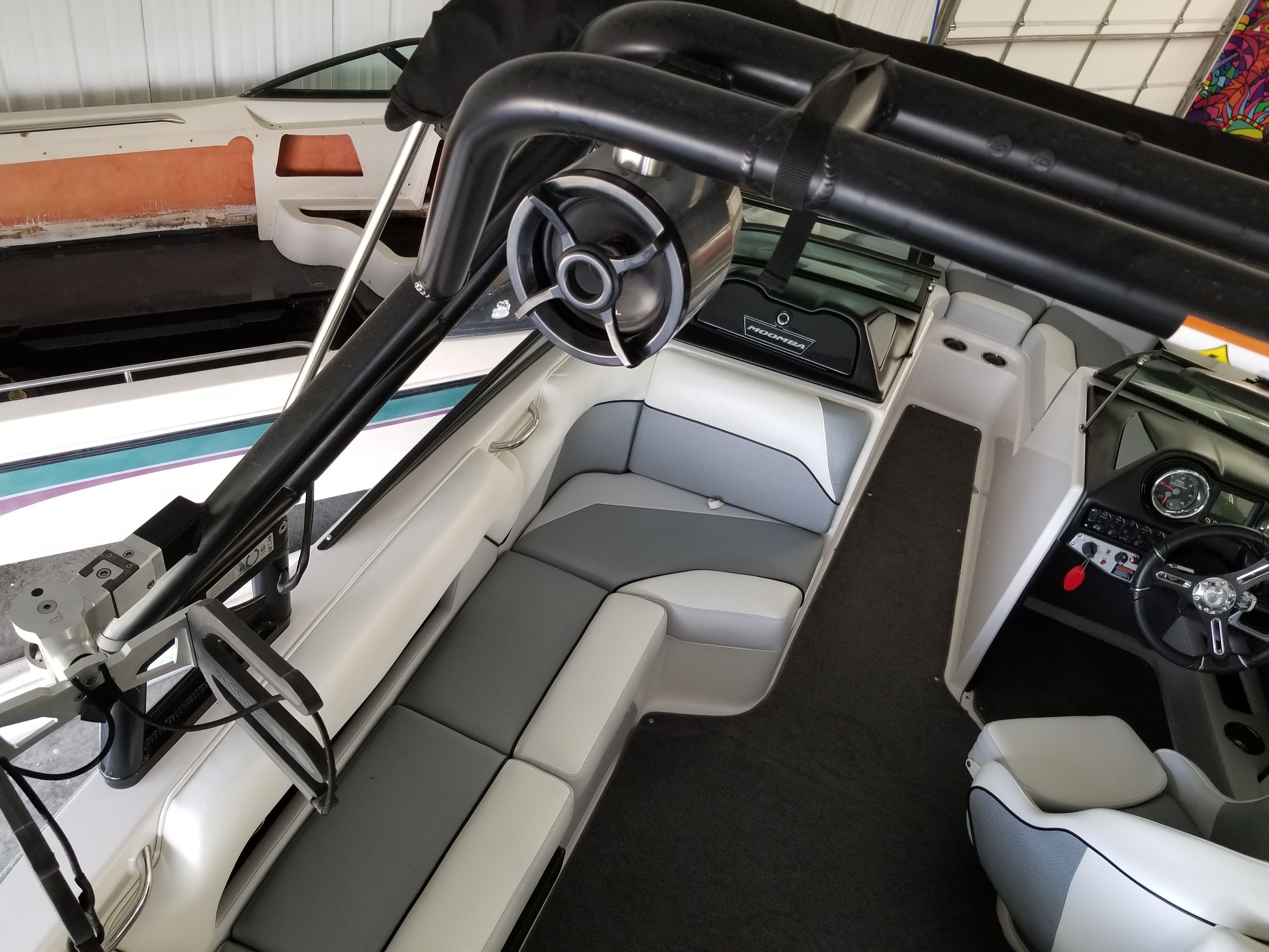 Interior view of a 2016 Moomba Mondo with gray and white seating and a black wakeboard tower.