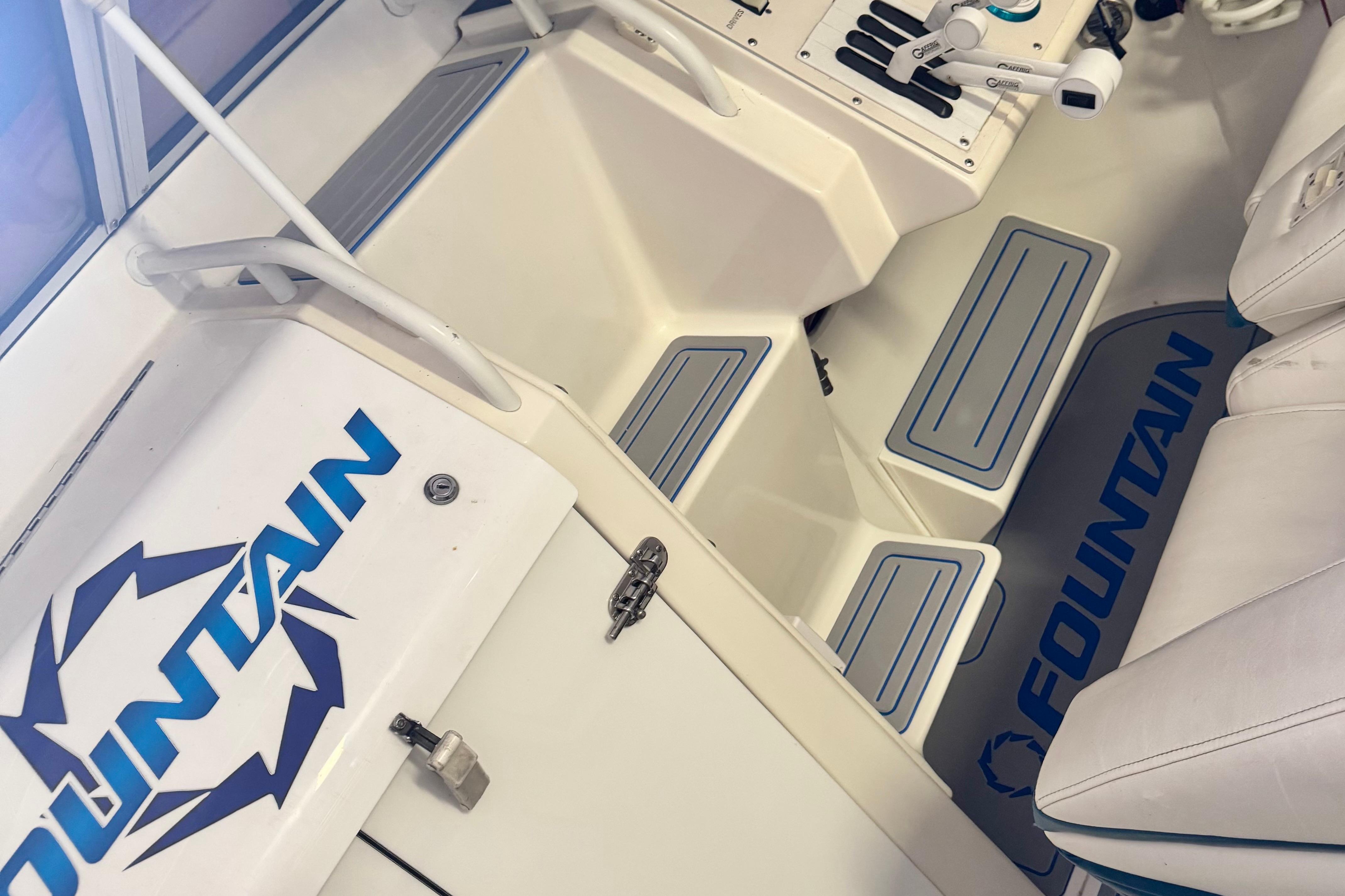 1999 Fountain 38 SC boat interior with logo, white seating, and blue accents.