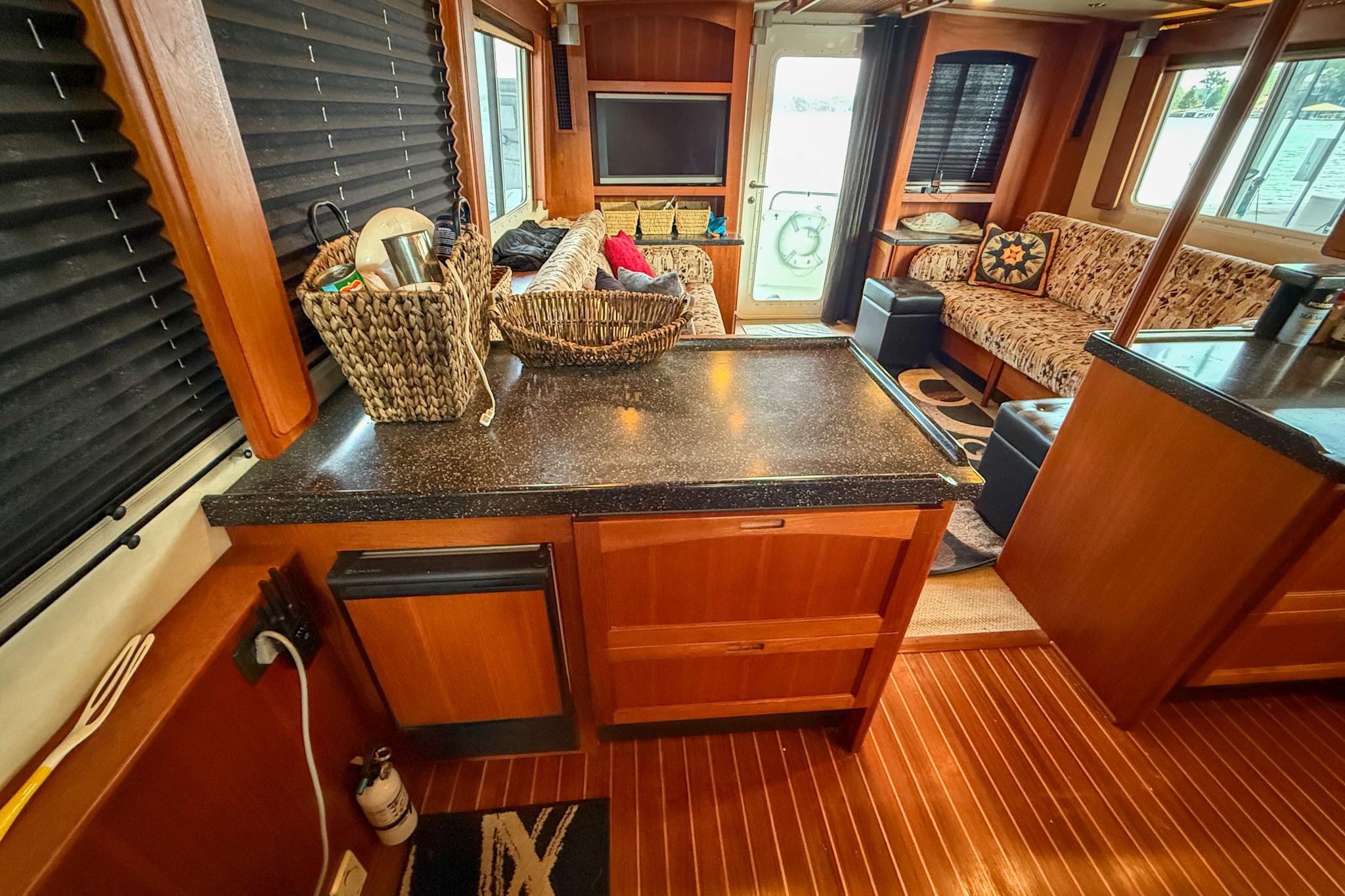 Interior of 2007 Nordic Tug 54, featuring cozy seating and wooden cabinetry.