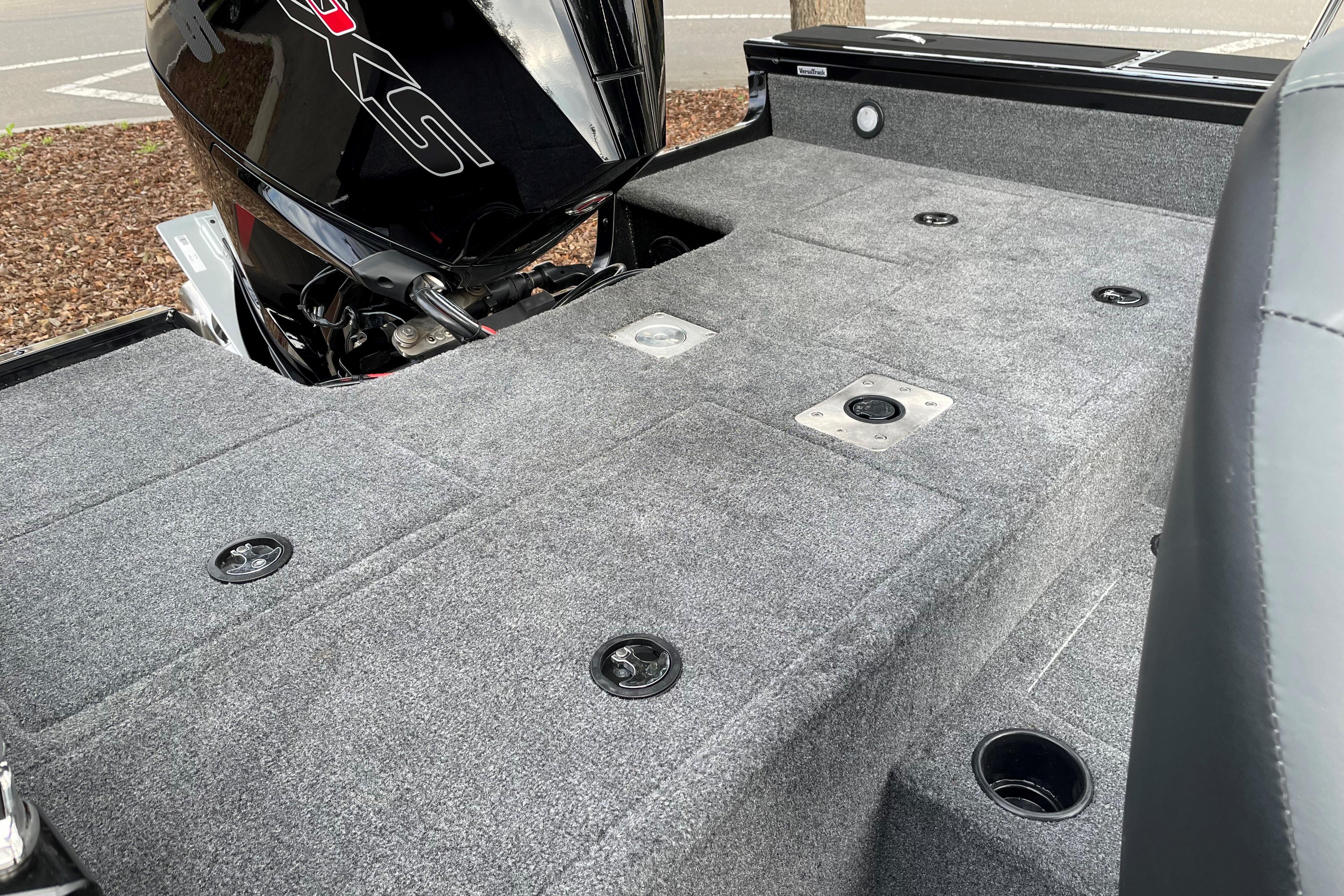 2026 Tracker Targa V-19 WT boat deck with motor, featuring carpeted surface and storage compartments.