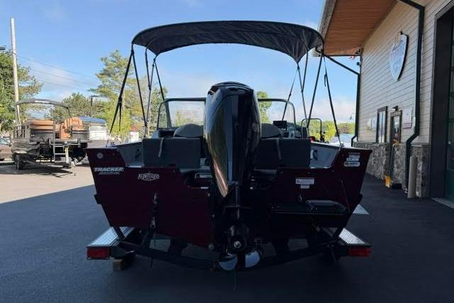 2017 Tracker Pro Guide V-175 Combo boat with canopy, parked outside a building.