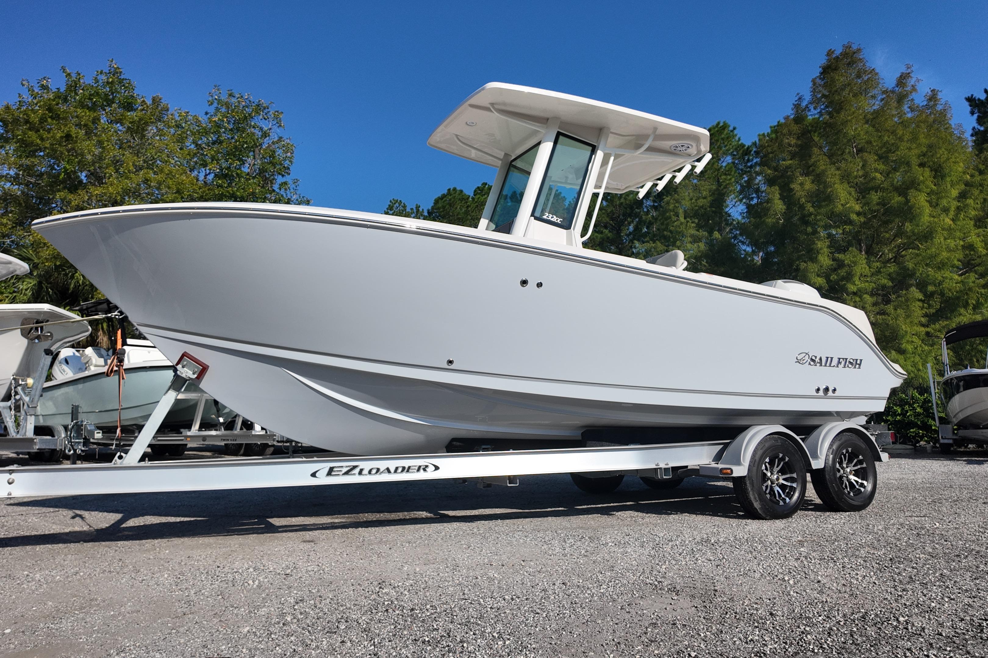 2026 Sailfish 232 CC boat on EZ Loader trailer, parked outdoors under clear blue sky.