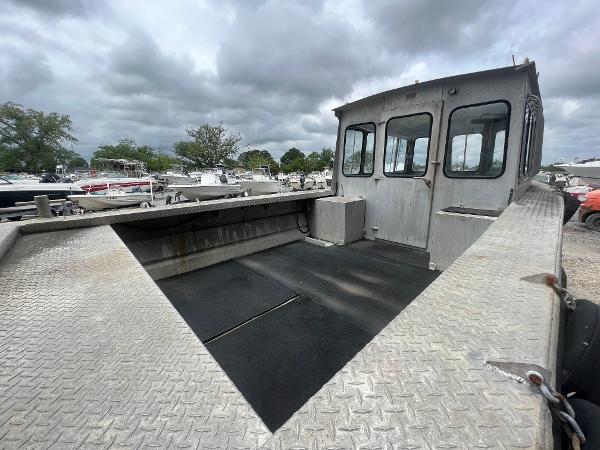 Custom Flat 28 Cabin Boat, 2010 model, with spacious deck and cabin, under cloudy skies.