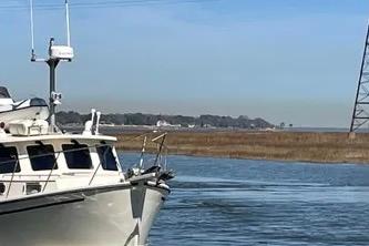 1997 Rosborough Trawler on calm water with distant shoreline and clear sky.