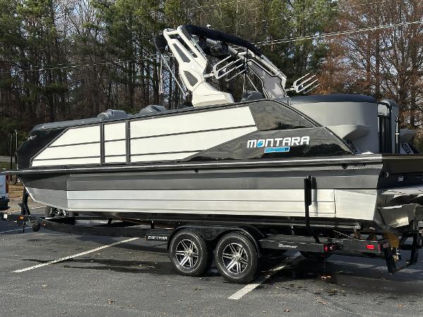 2025 Montara Surf Boss 2.0 25 boat on trailer in parking lot.