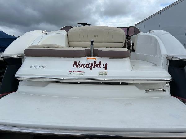 2010 Cobalt 262 boat with "Naughty" decal on the stern, under cloudy skies.