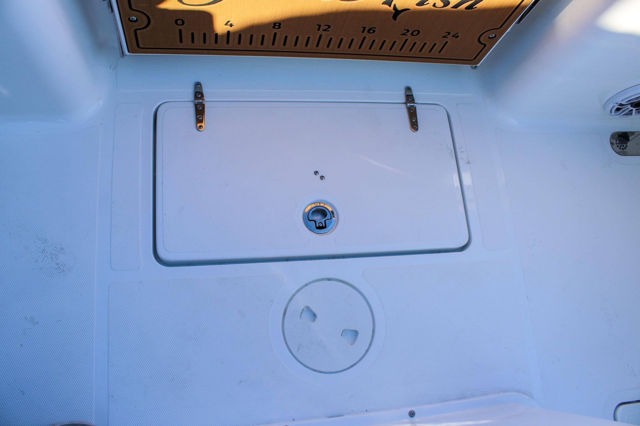 2026 Sea Hunt Gamefish 25 deck with storage compartment and measuring board.