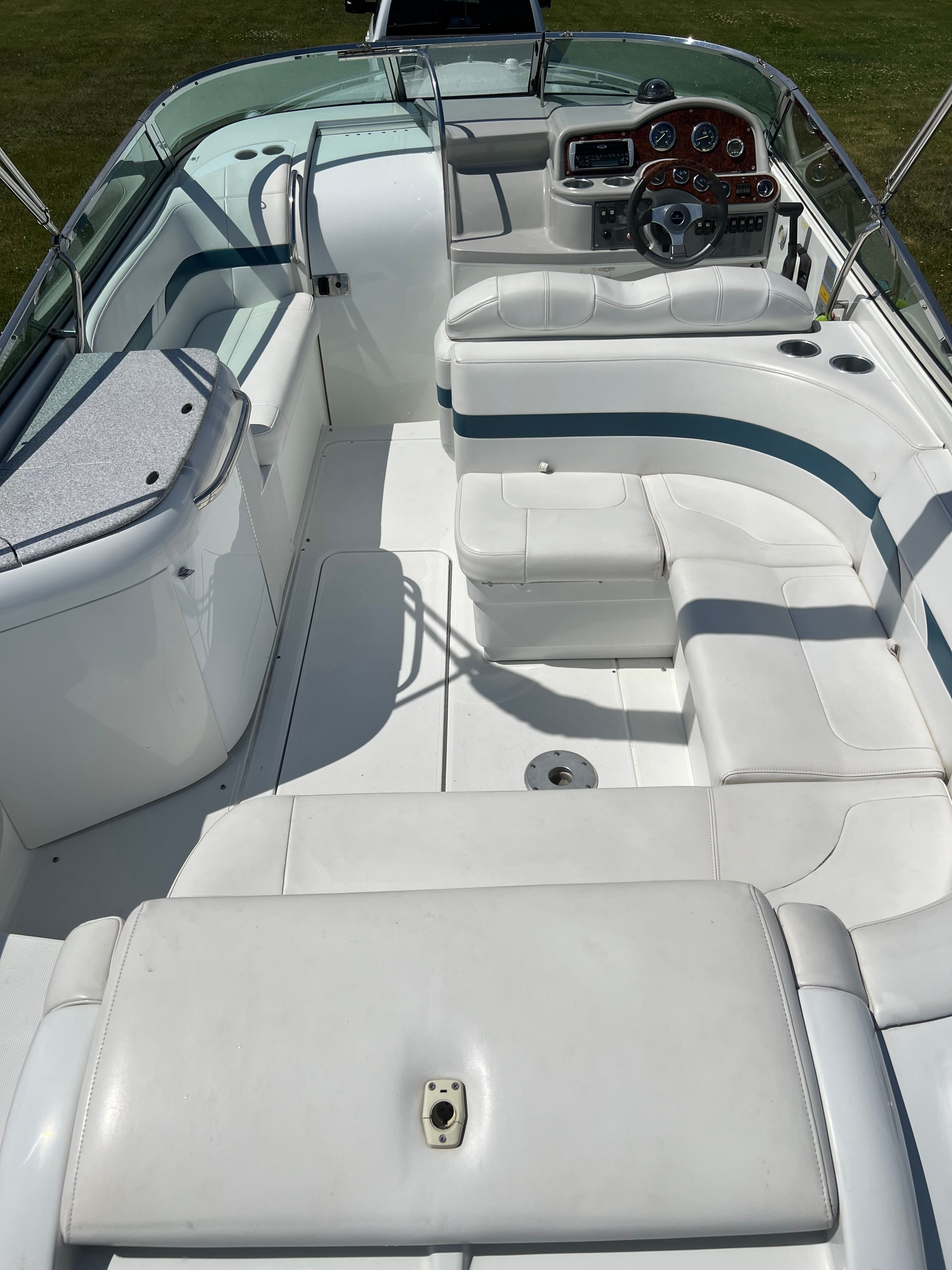 The image shows the cockpit of a 2005 Formula 260 Sun Sport with white upholstery and a helm.