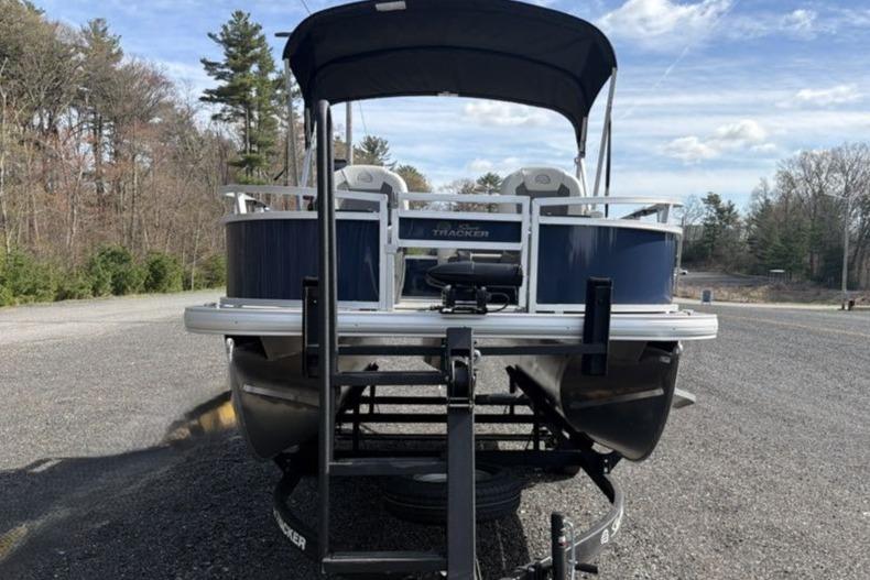 2026 Sun Tracker Bass Buggy 16 XL Select pontoon boat on trailer, parked outdoors.