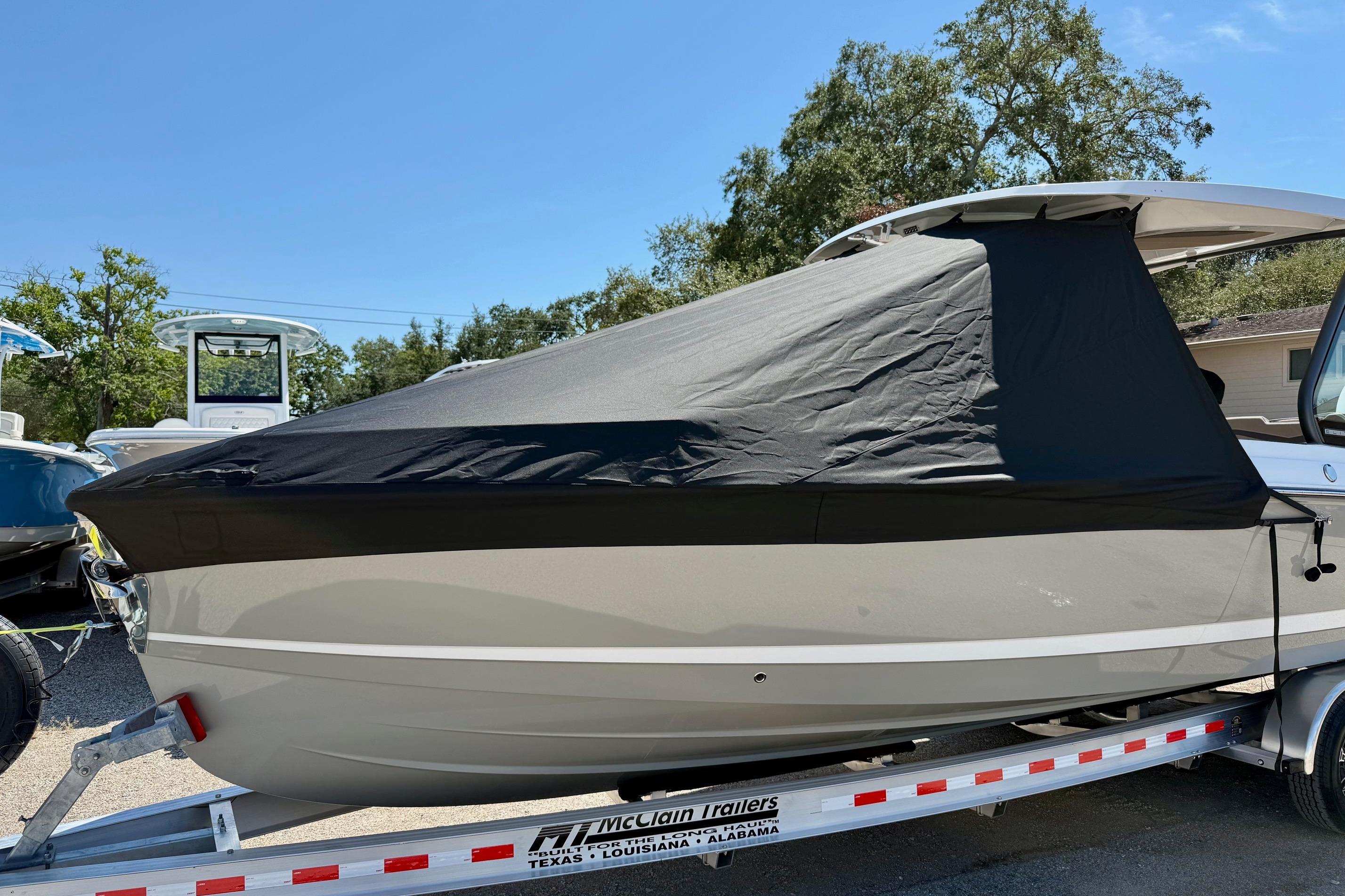 2026 Monterey Elite 27 OB boat covered on a trailer under a clear blue sky.