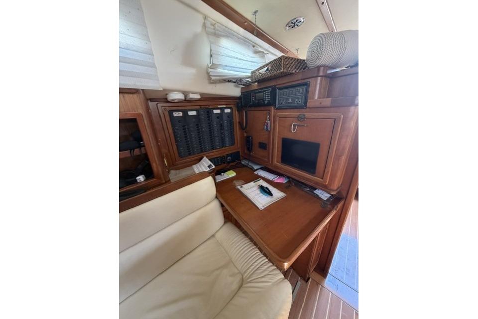 Interior of 2002 Saga 43 yacht with navigation station and wooden cabinetry.
