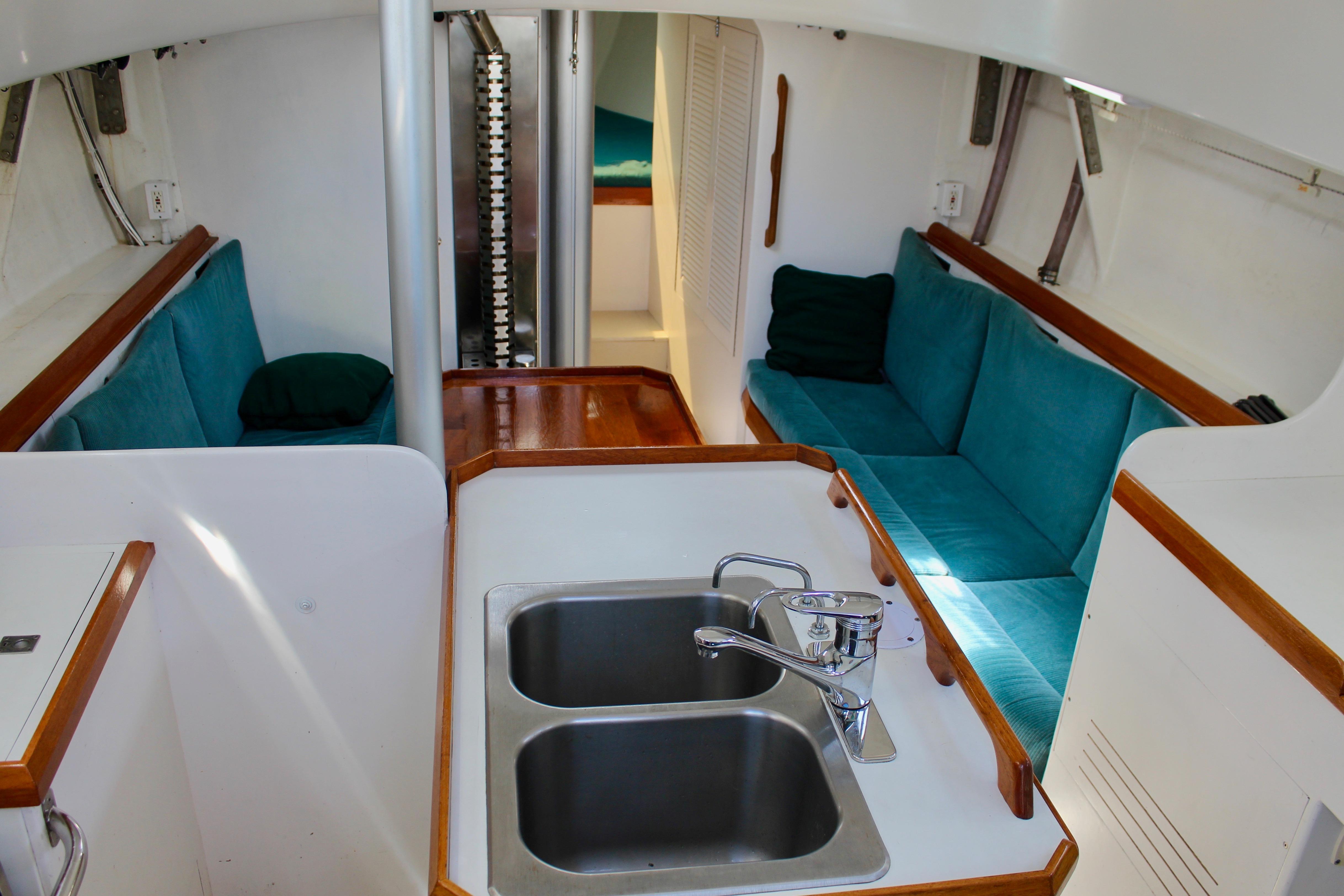 Interior of 1993 Freya 39 yacht with teal seating and dual sink.