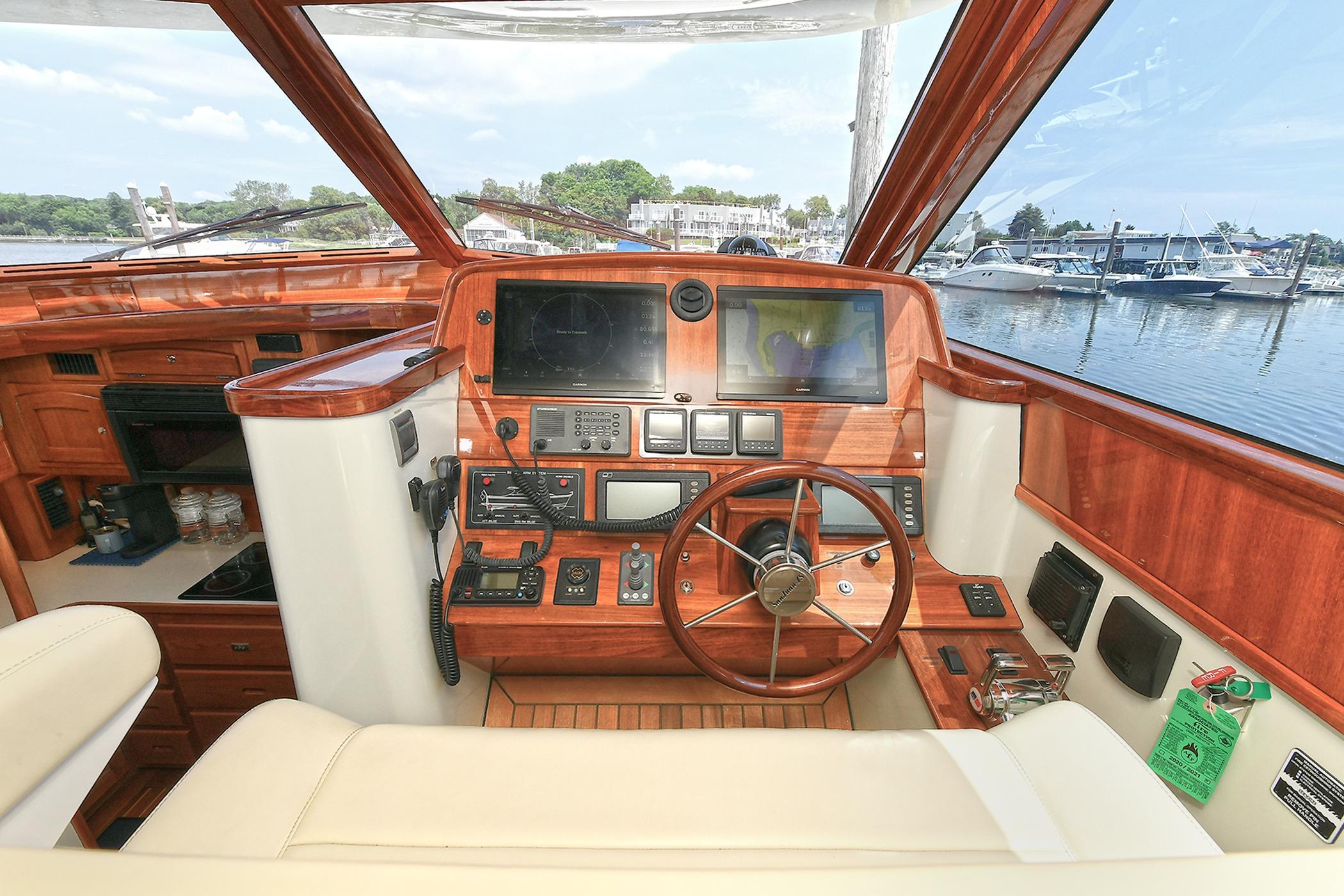 Interior view of 2005 San Juan Downeast Express boat cockpit with wooden dashboard.