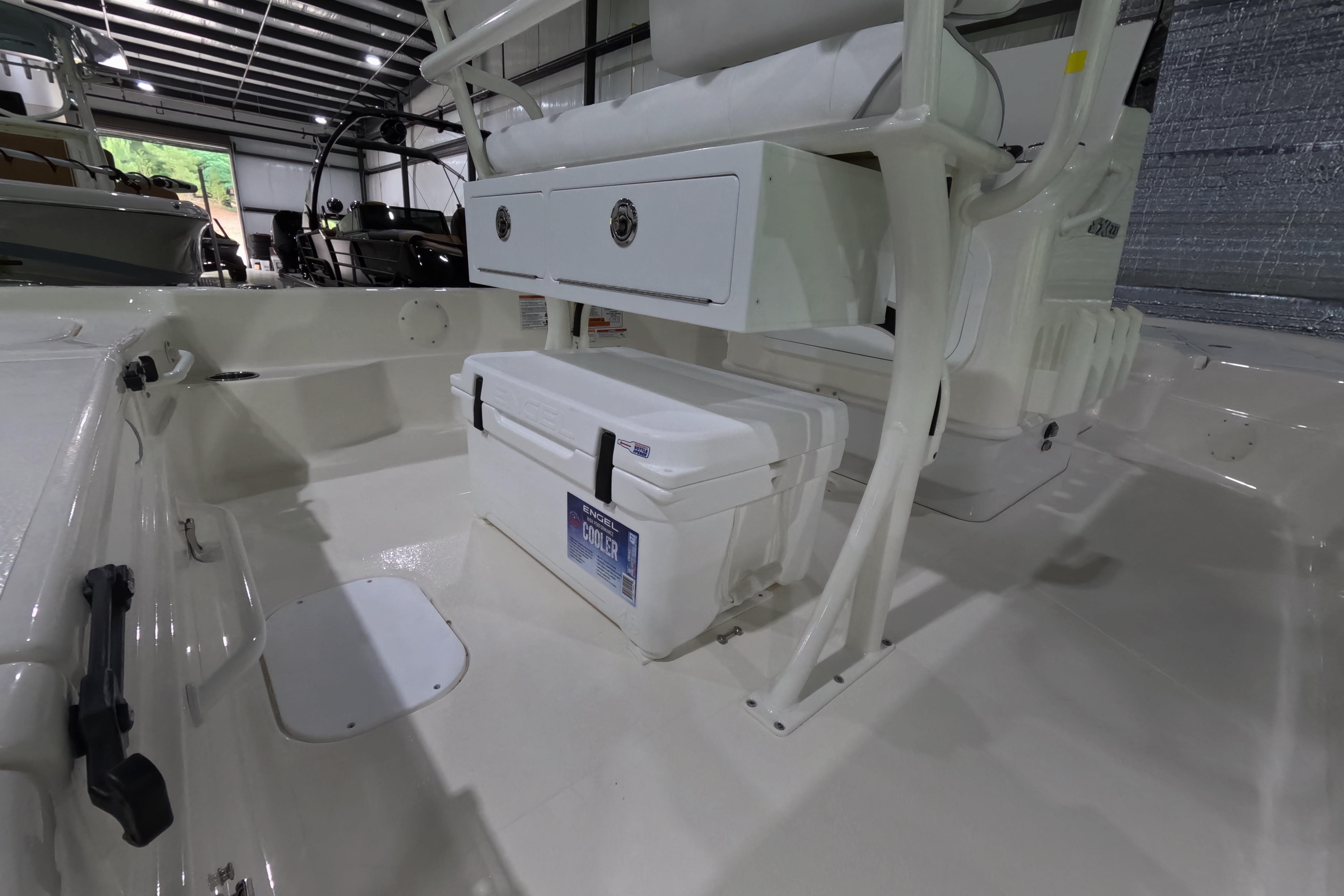 2026 Skeeter SX221 boat interior with cooler and storage in a spacious garage.