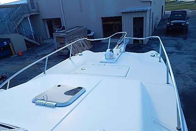 2003 World Cat 270 EC boat deck with railing and hatch, parked near a building.