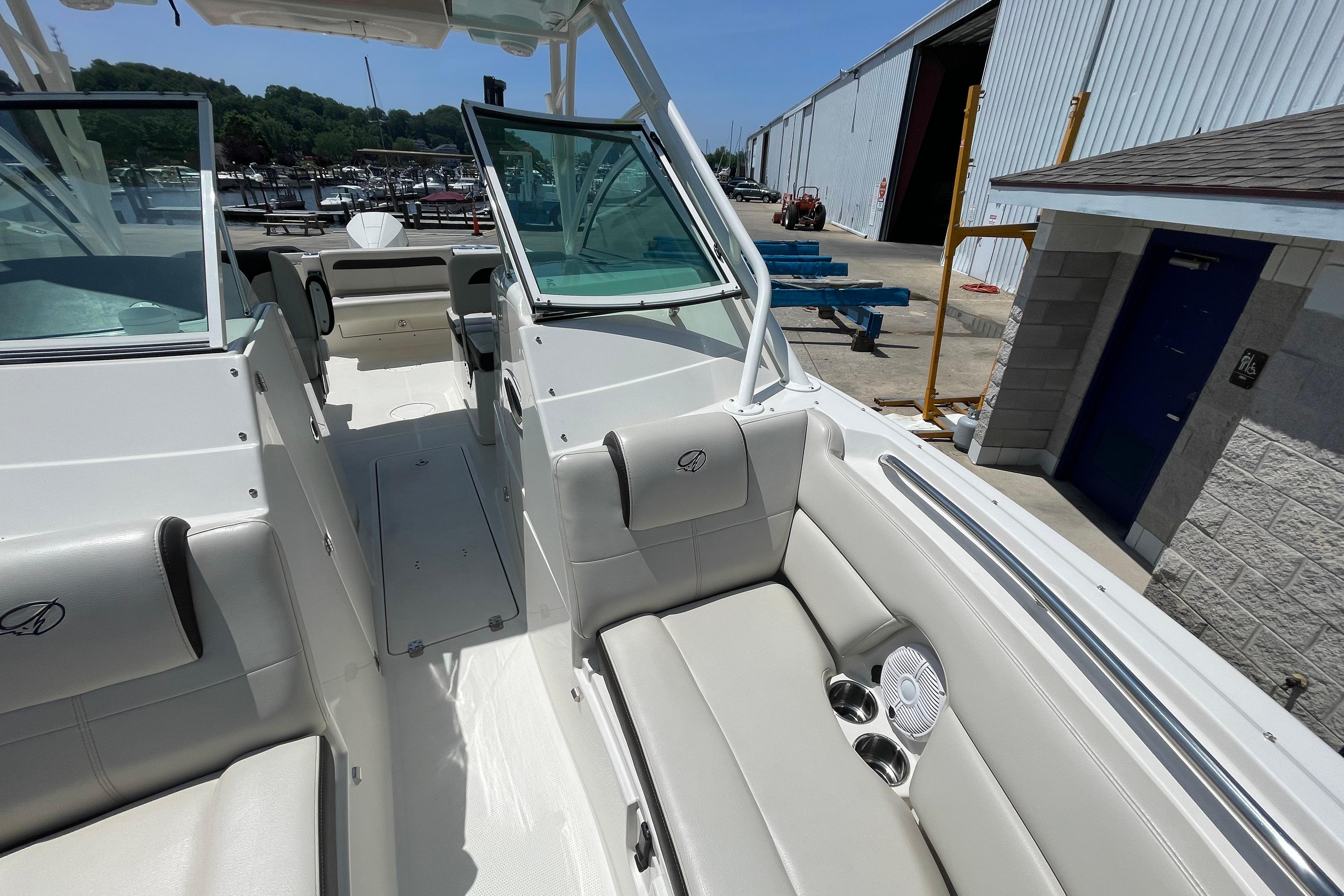 2022 Sailfish 245 DC boat interior with plush seating and cup holders at a marina.