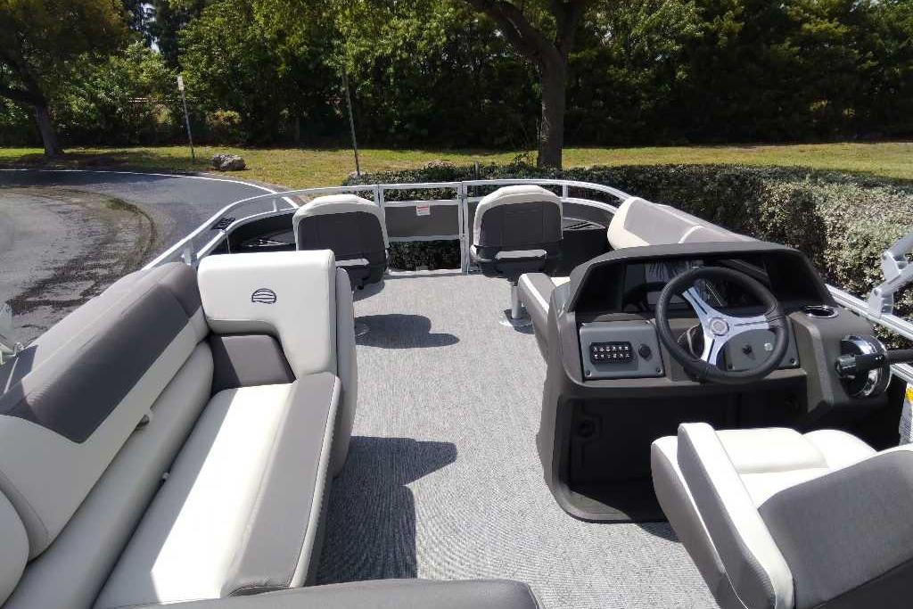 2026 Sun Tracker Fishin' Barge 22 DLX pontoon boat interior with seating and steering console.